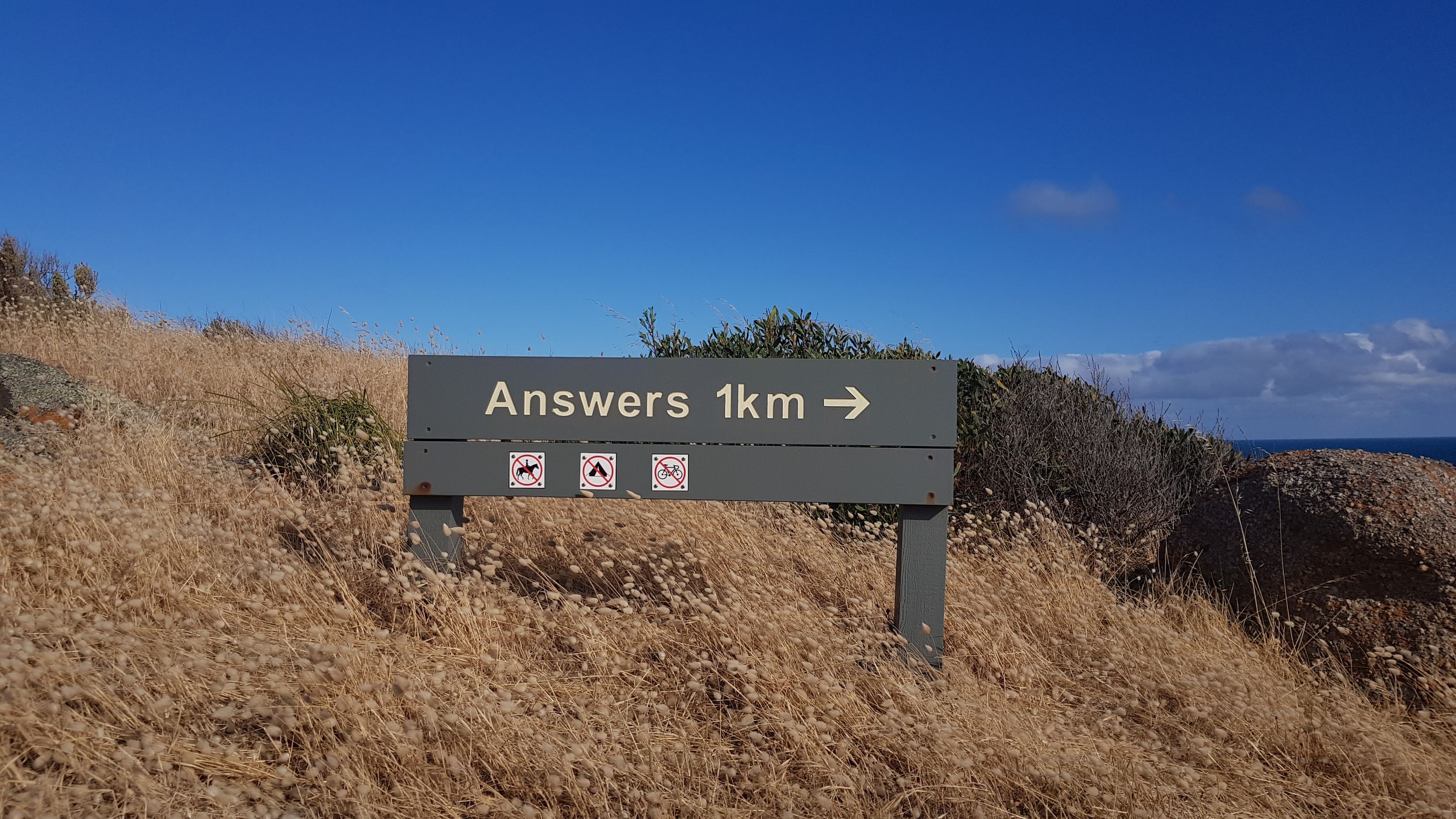 Photo of a road sign reading ‘Answers 1km’ with an arrow pointing right