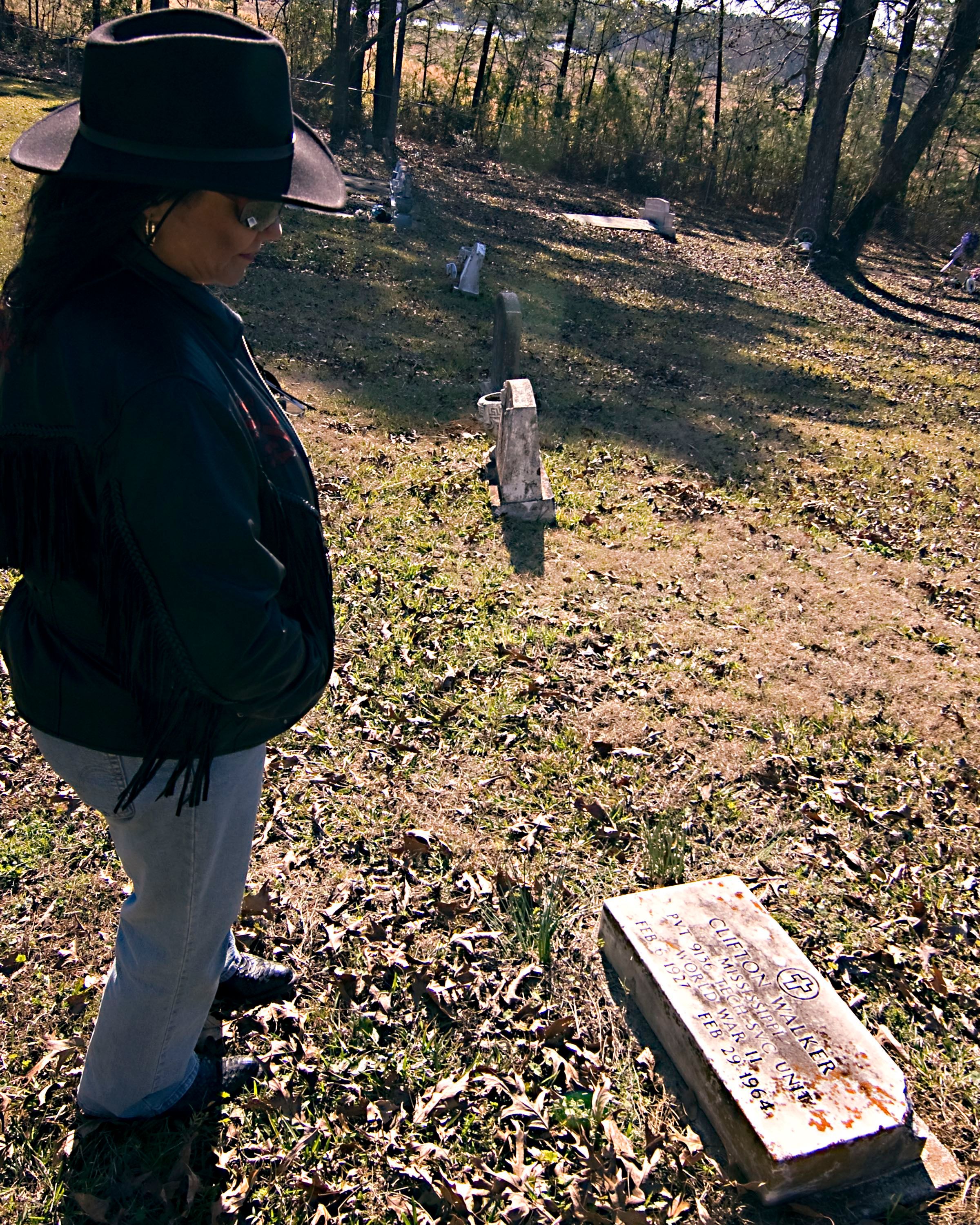 Catherine Walker stands looking at her father’s grave, outside Woodville, Miss. Photo by Ben Greenberg