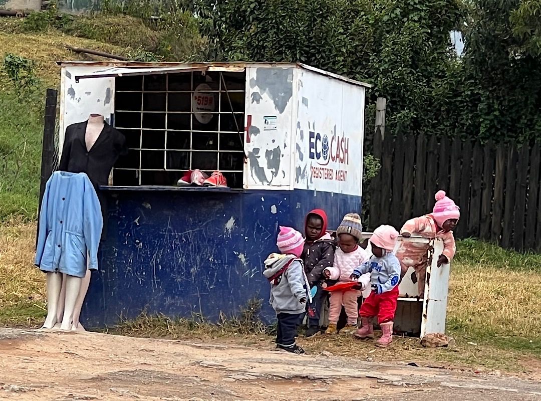 Children playing besides an old Ecocash booth