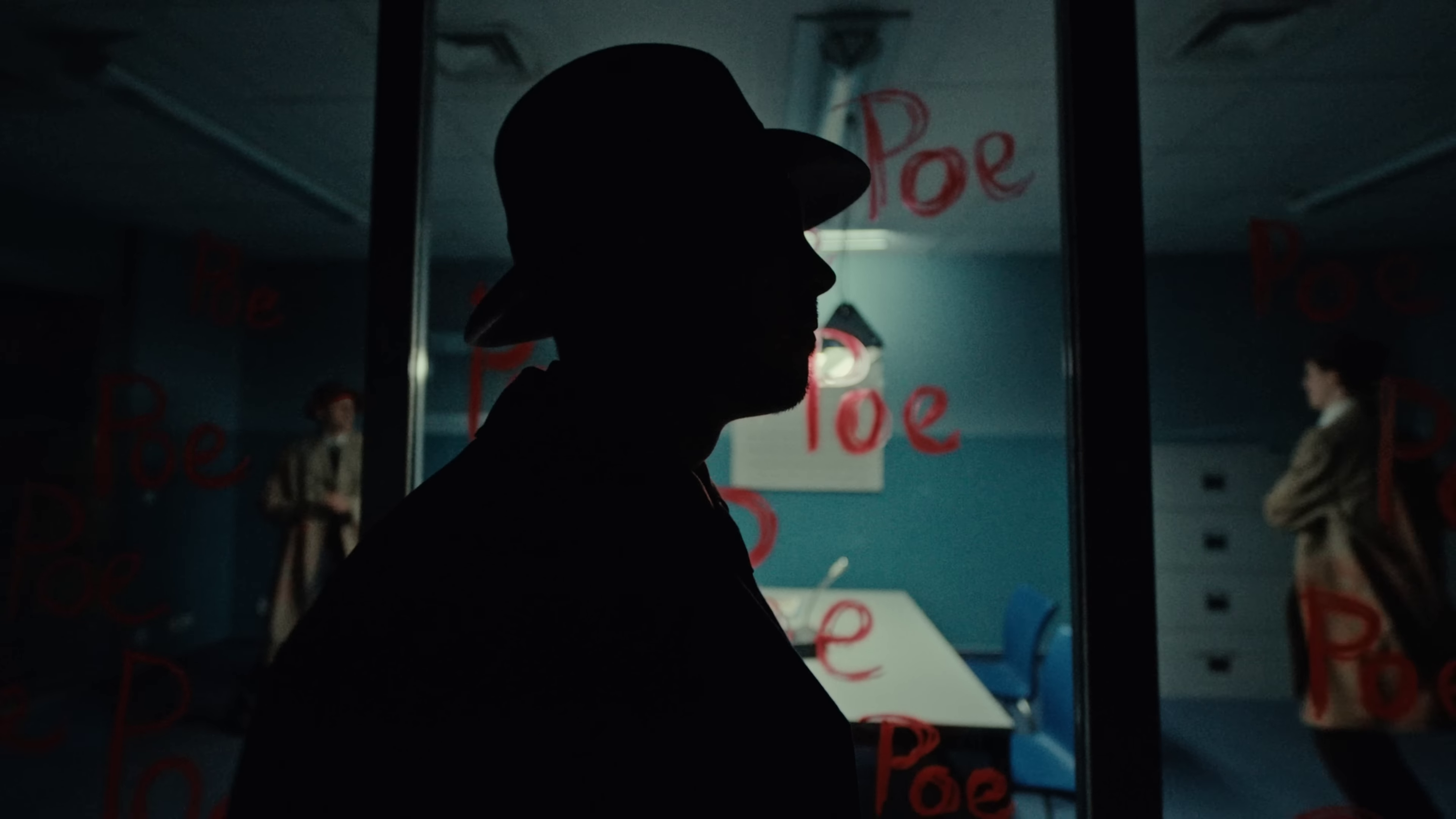 image of a silhouette of a man in front of a window, on which is written the word “Poe” in red lipstick