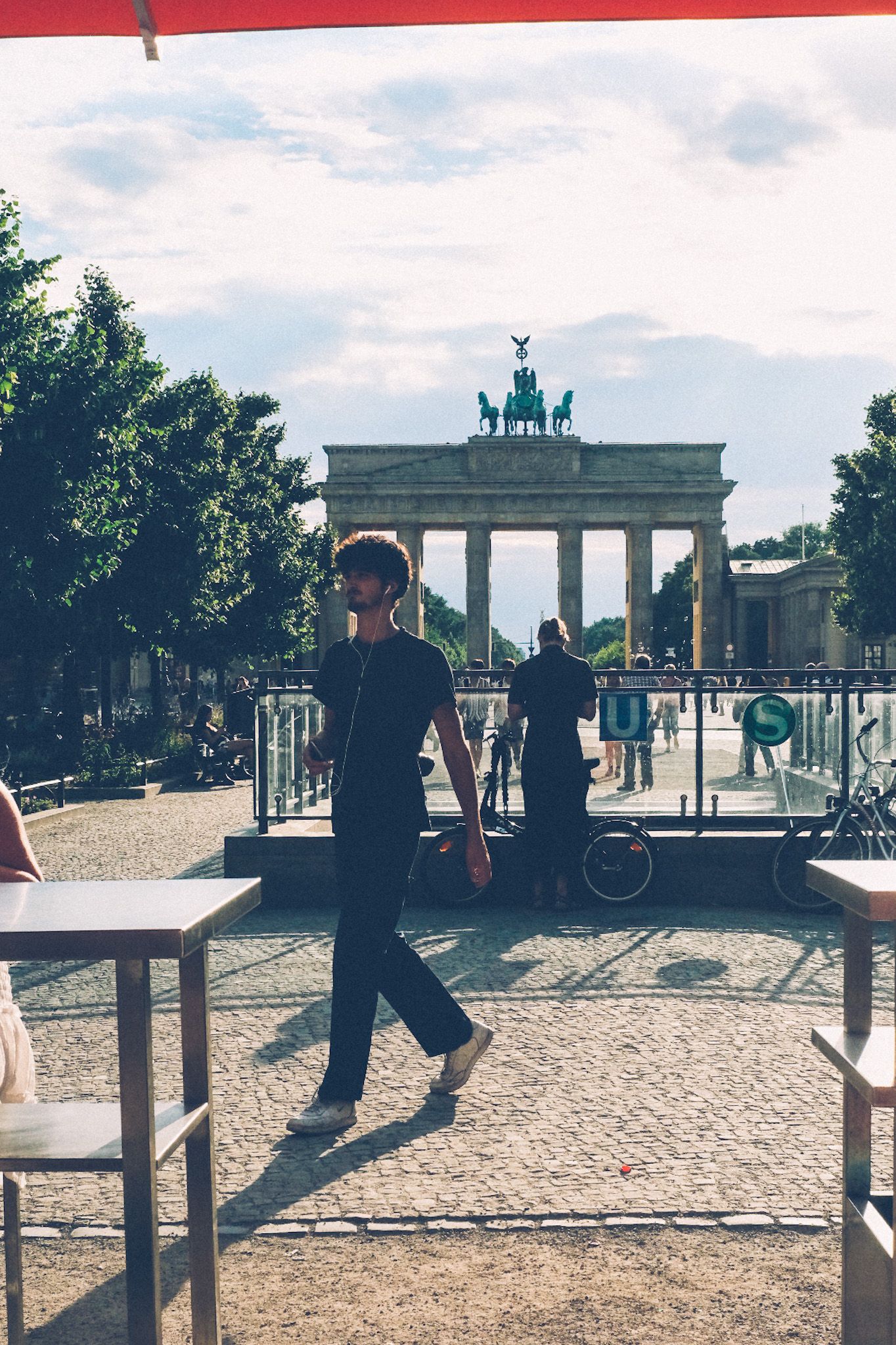 On a sunny afternoon, a man passes in front of Berlin’s Brandenberg Gate.