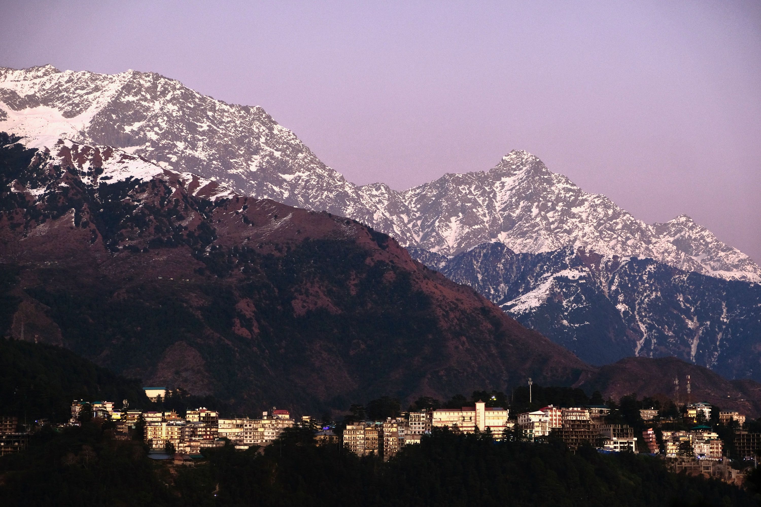 The Dhauladhar range of the Himalaya at dusk and the town of Dharamshala, Himachal Pradesh, India. December 2019.