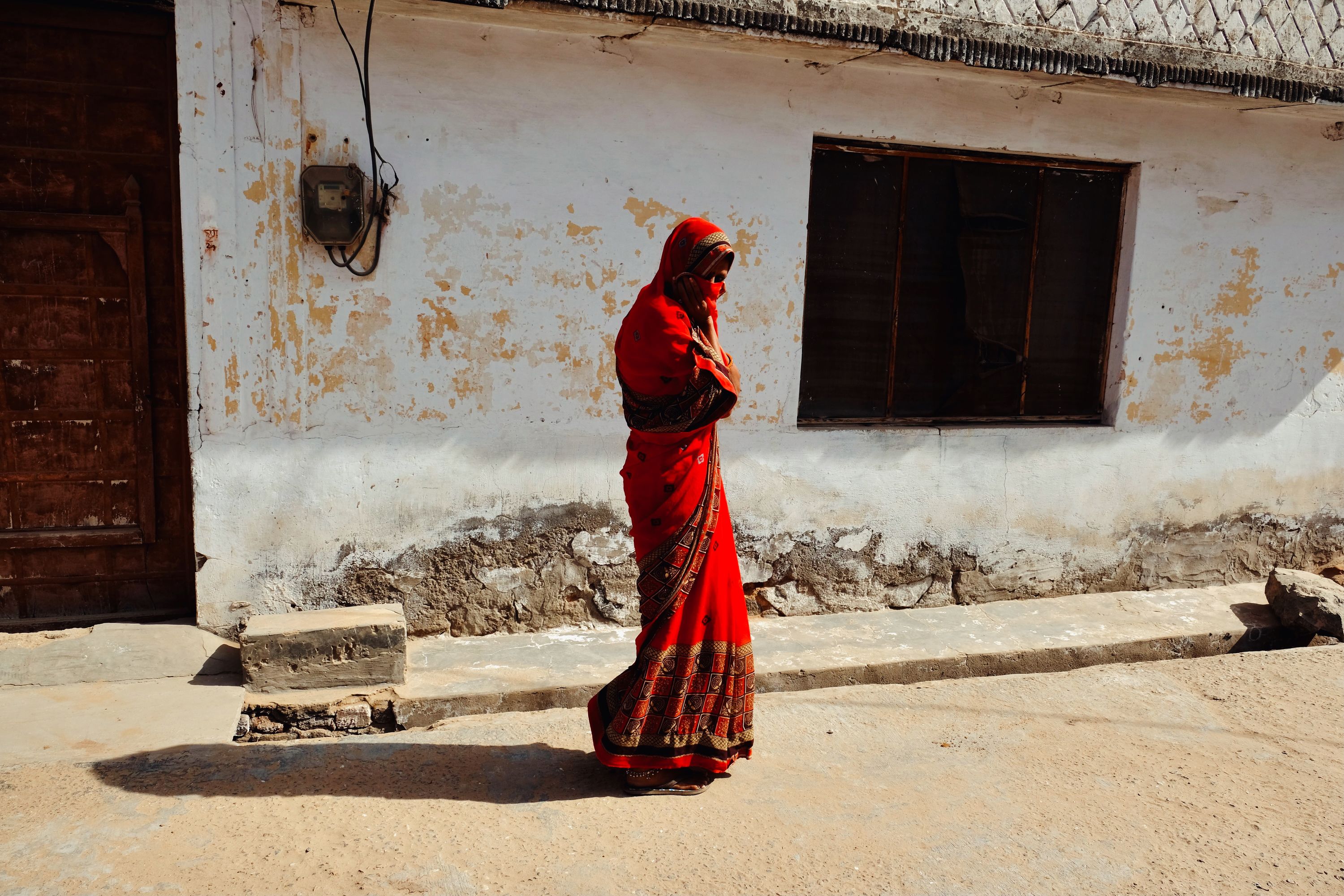 Woman in a red sari. Mandawa, Rajasthan, India. January 2021.