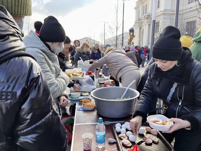 Volunteers serve meals to evacuees in front of the railway station in Lviv (Newscom/Alamy)