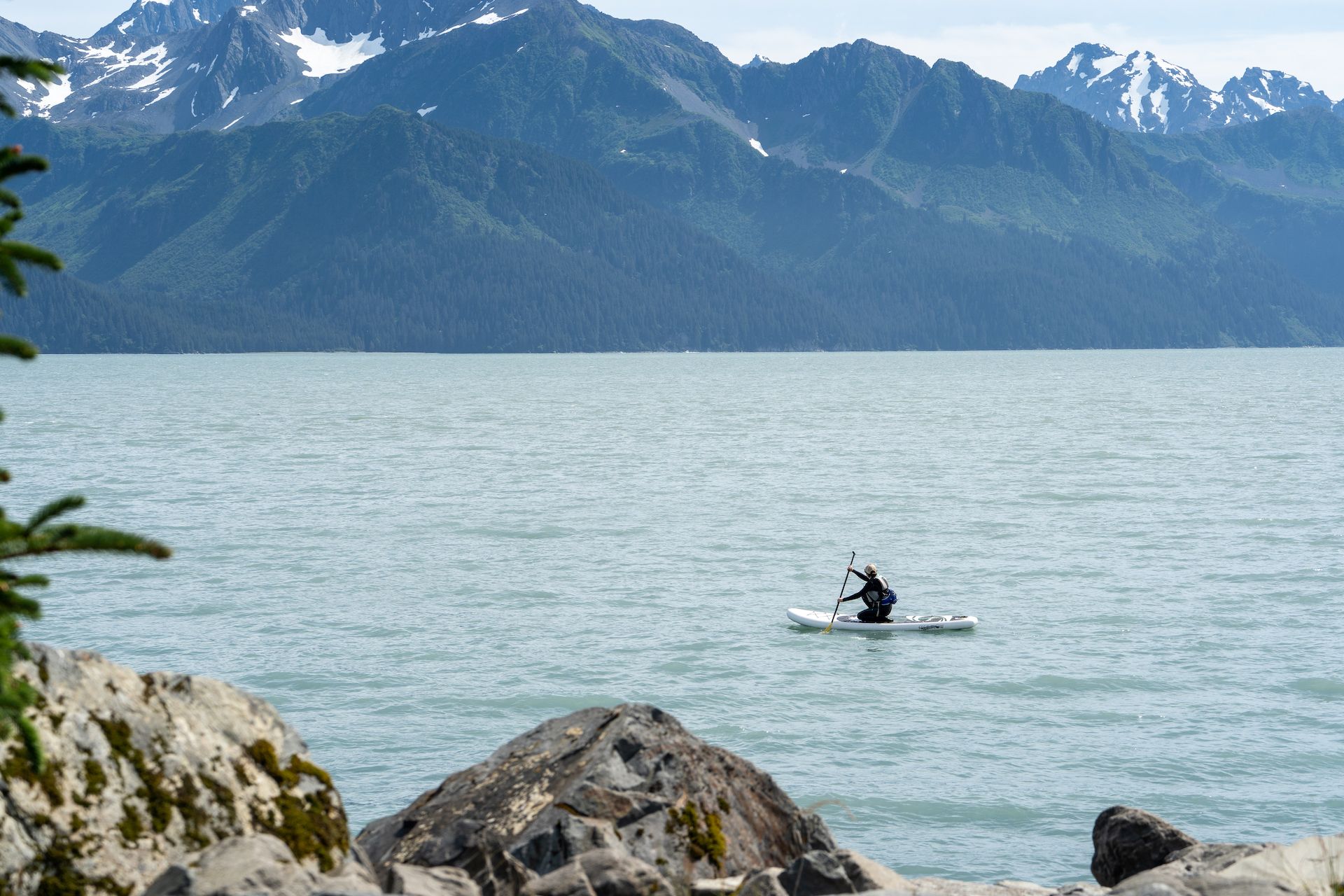A paddle boarder enjoying the calm water of Resurrection Bay