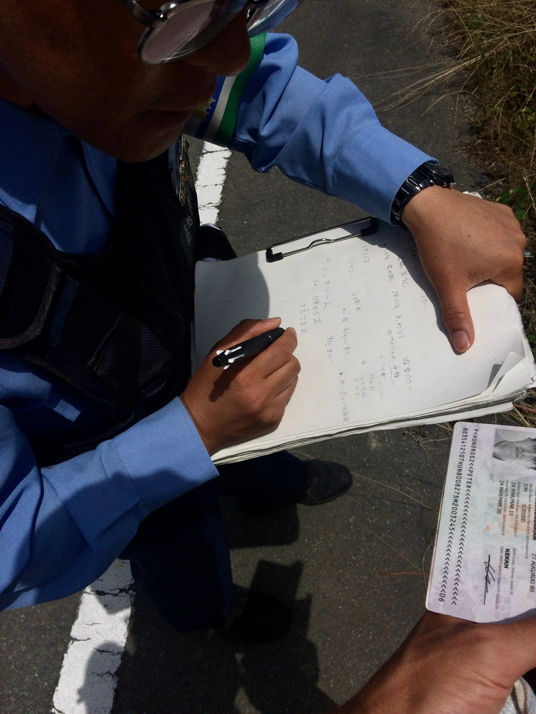 A policeman copies my passport data into his notebook.