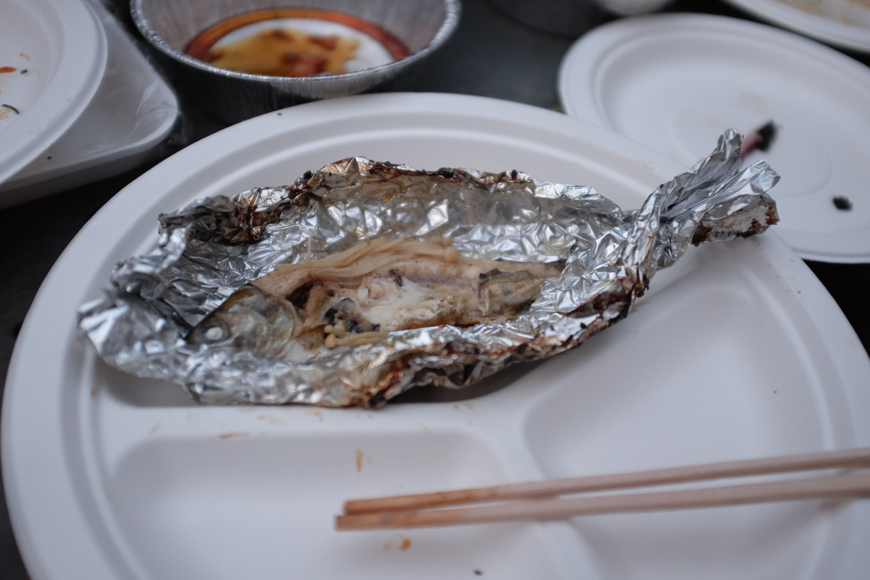 One of the fish, a Japanese trout, unwrapped on a paper plate.