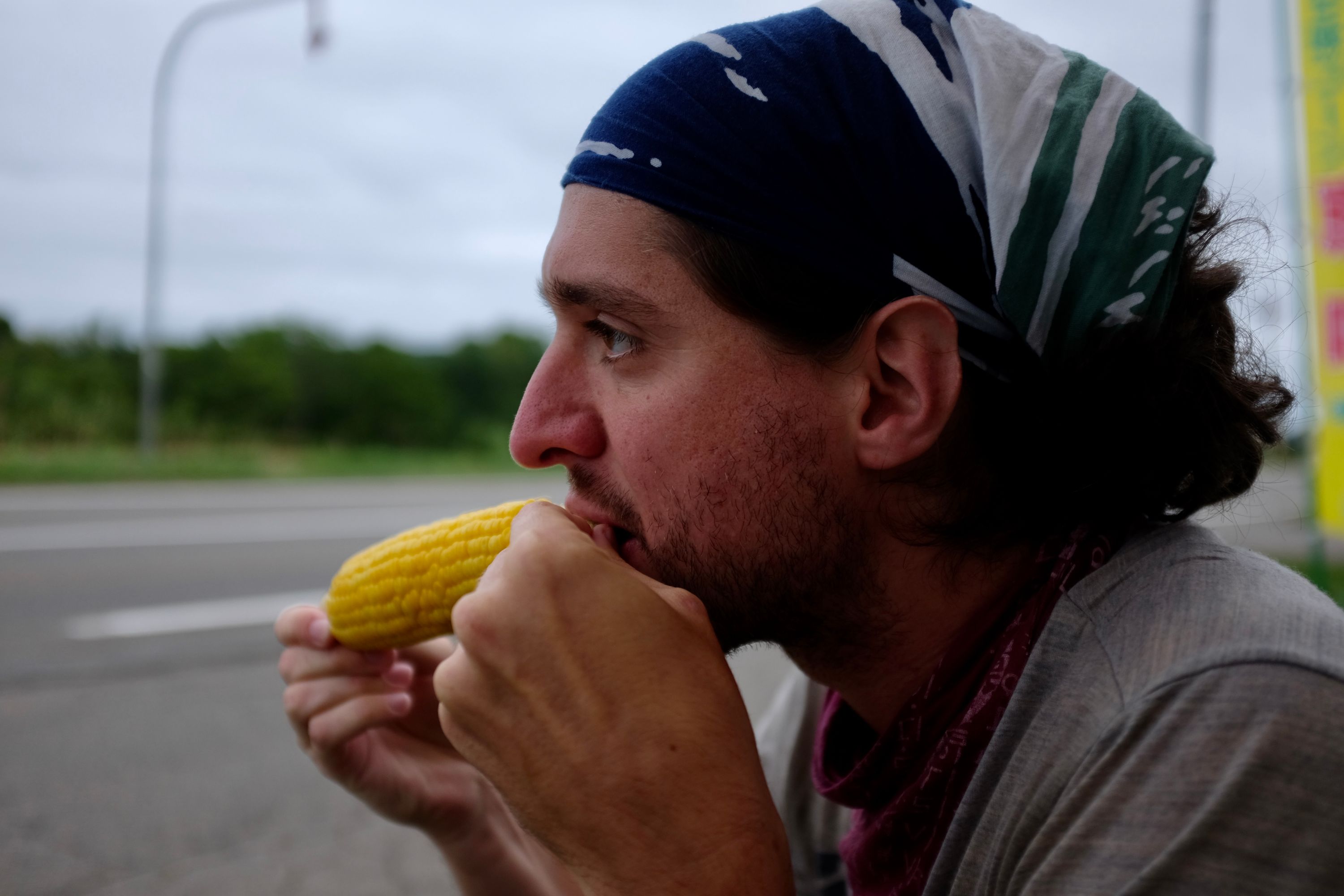 Portrait of Gabor eating corn on the cob.