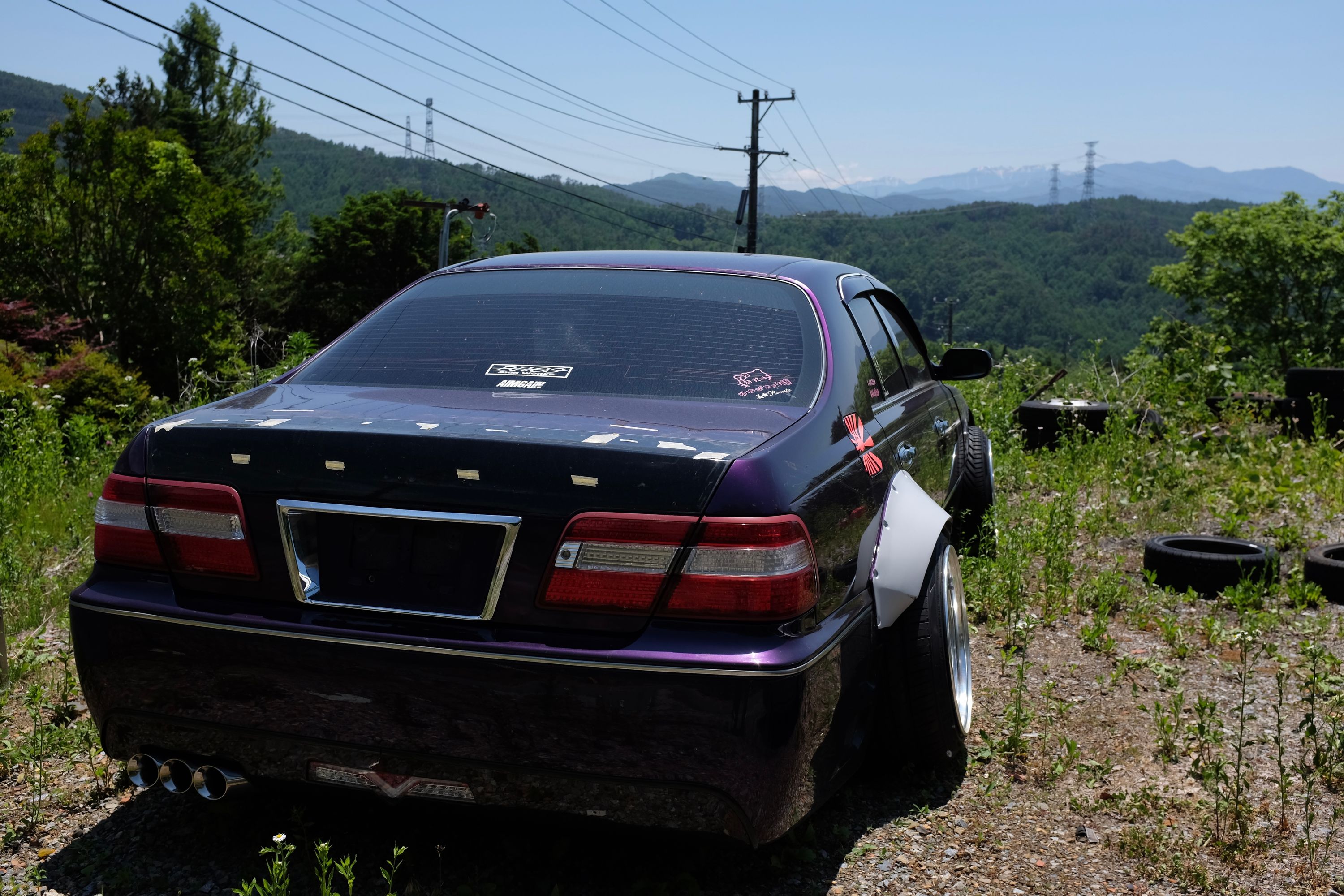 Rear view of the same car, with mountains on the horizon.