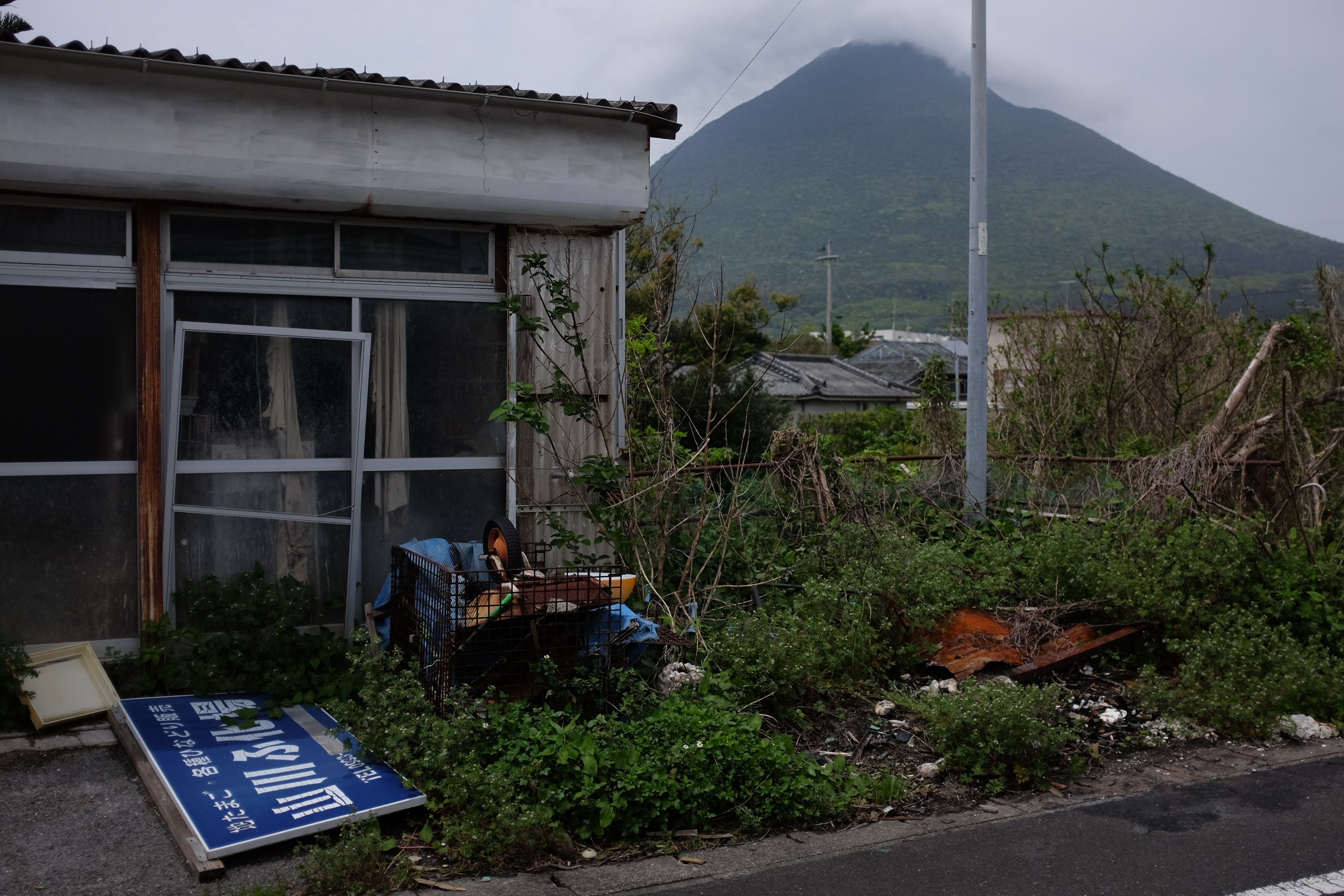 Mount Kaimon stands behind an abandoned house.