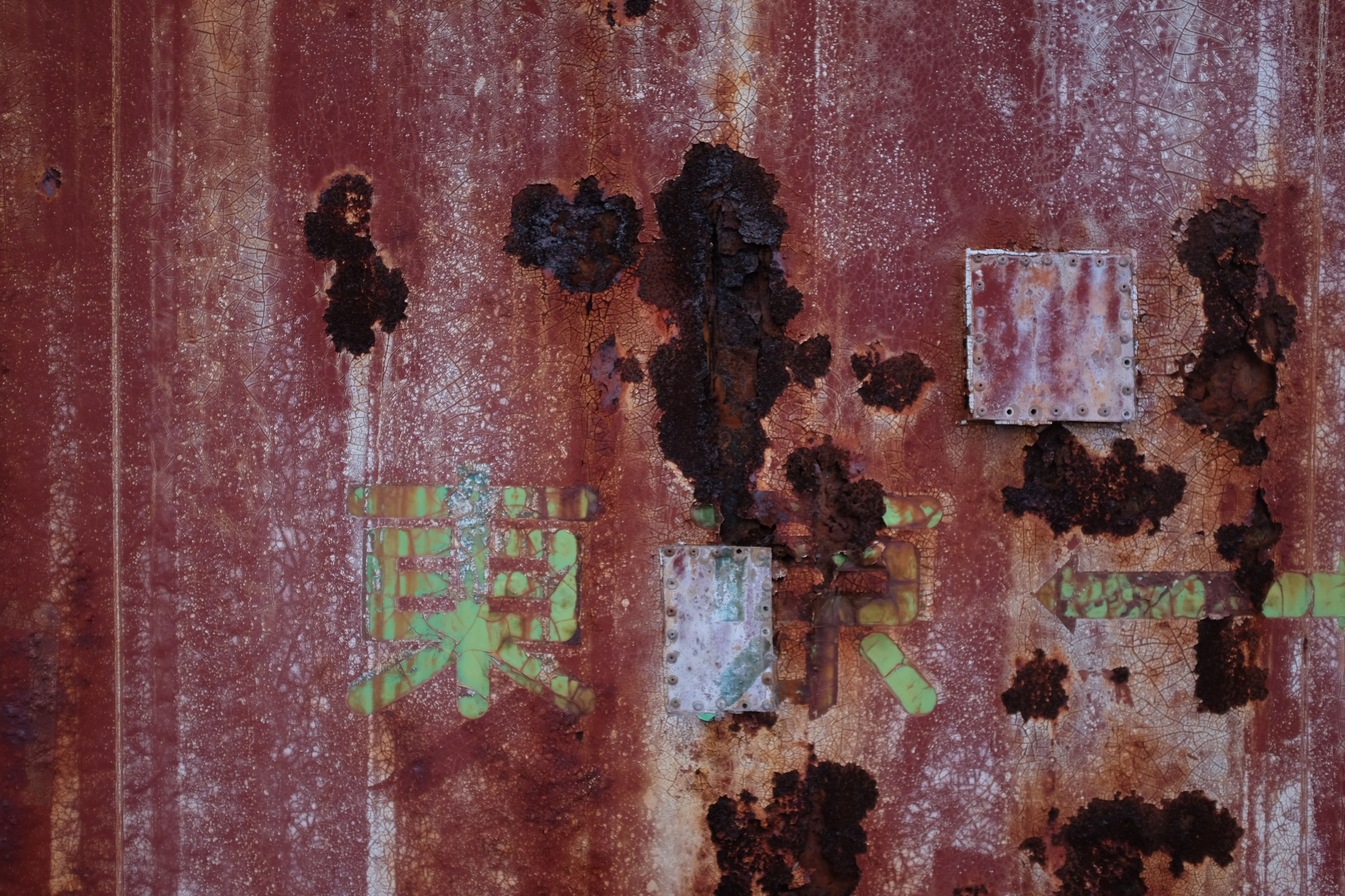 Closeup of the container shows the Japanese characters for Tokyo amid the rust.