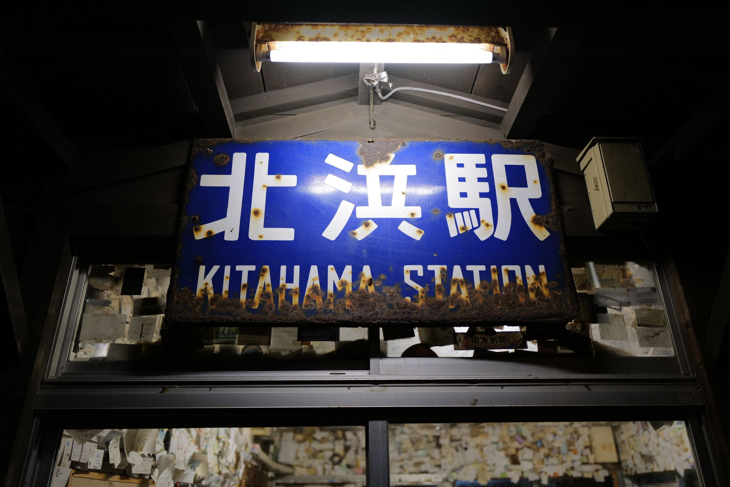 A rusty sign in the night says Kitahama Station