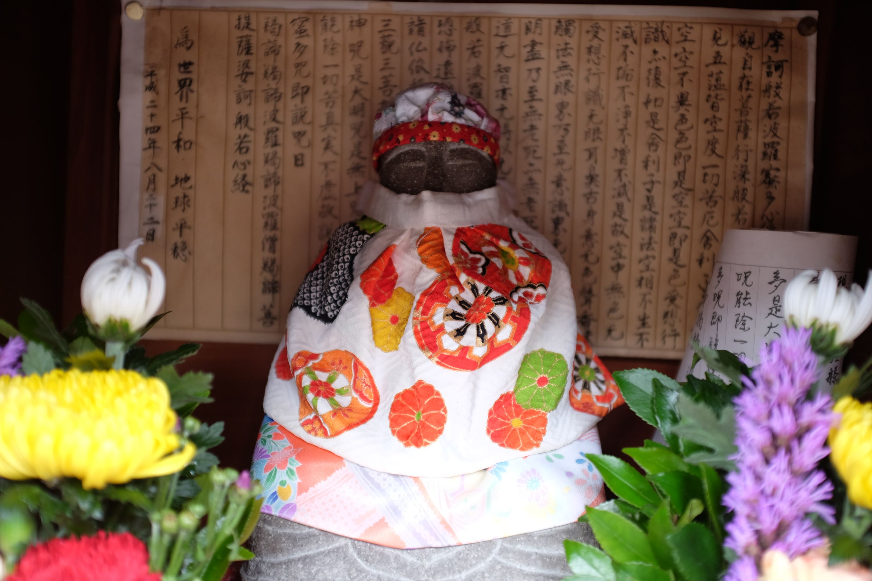 A Buddha statue on an altar decorated with flowers.
