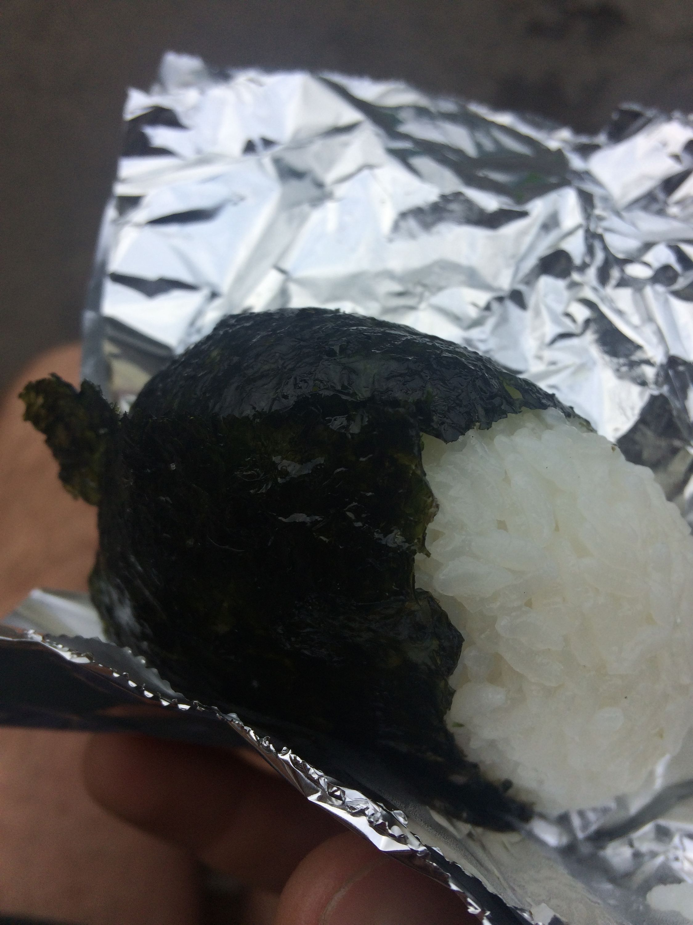 The author holds a fresh rice ball wrapped in seaweed.