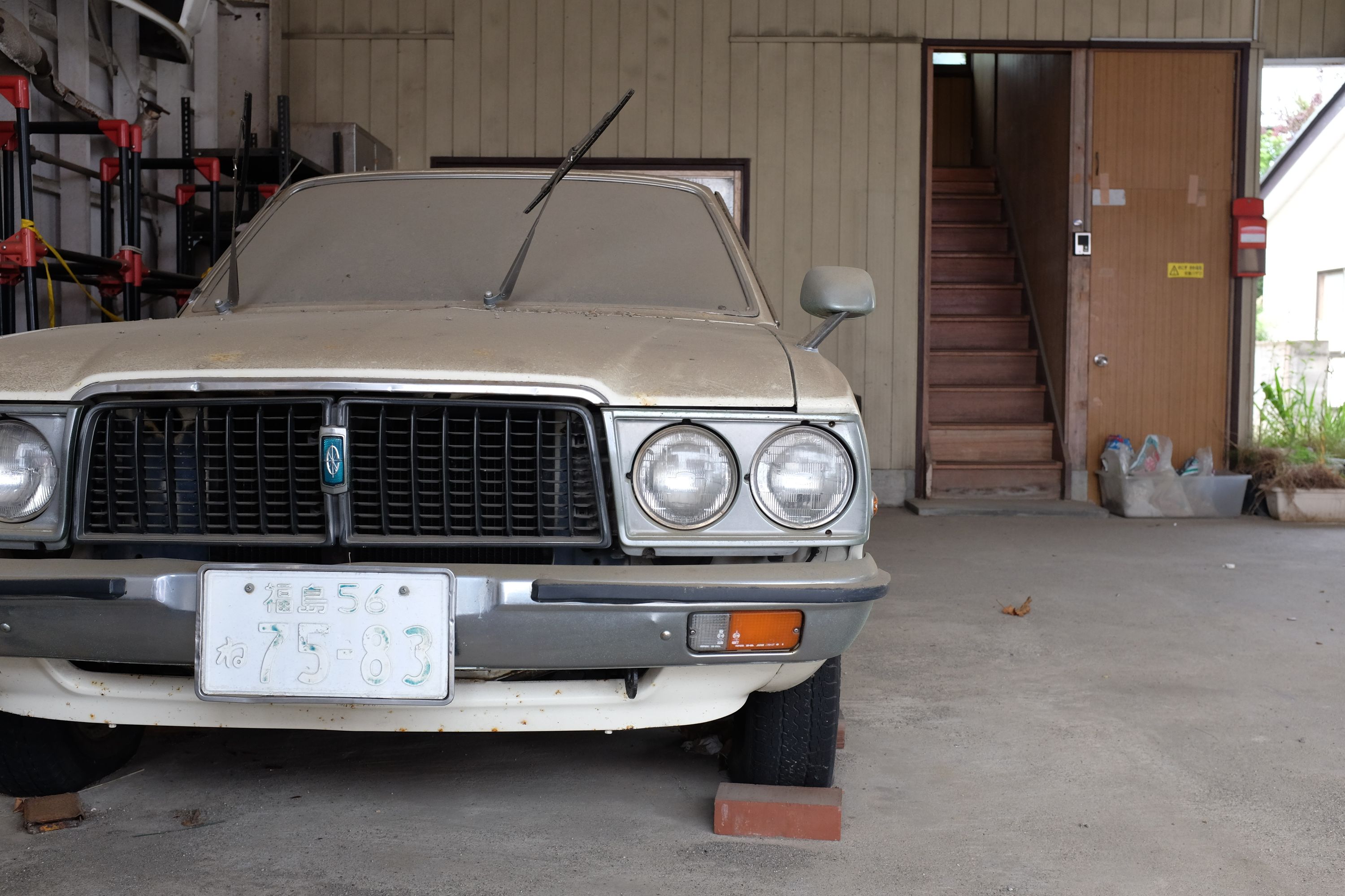 An abandoned vintage Toyota in a garage.