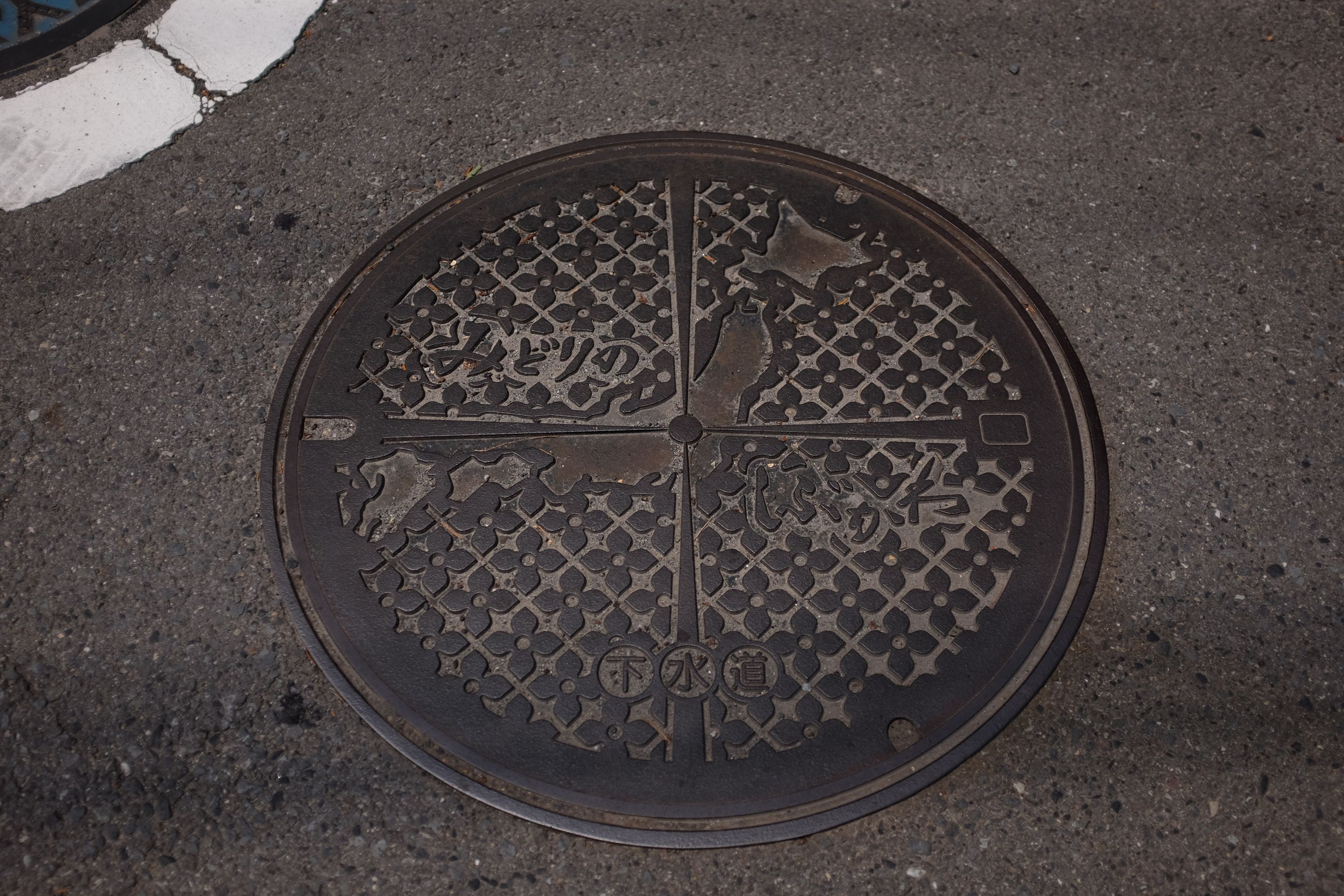 A manhole cover shows the city of Shibukawa as the center of Japan.