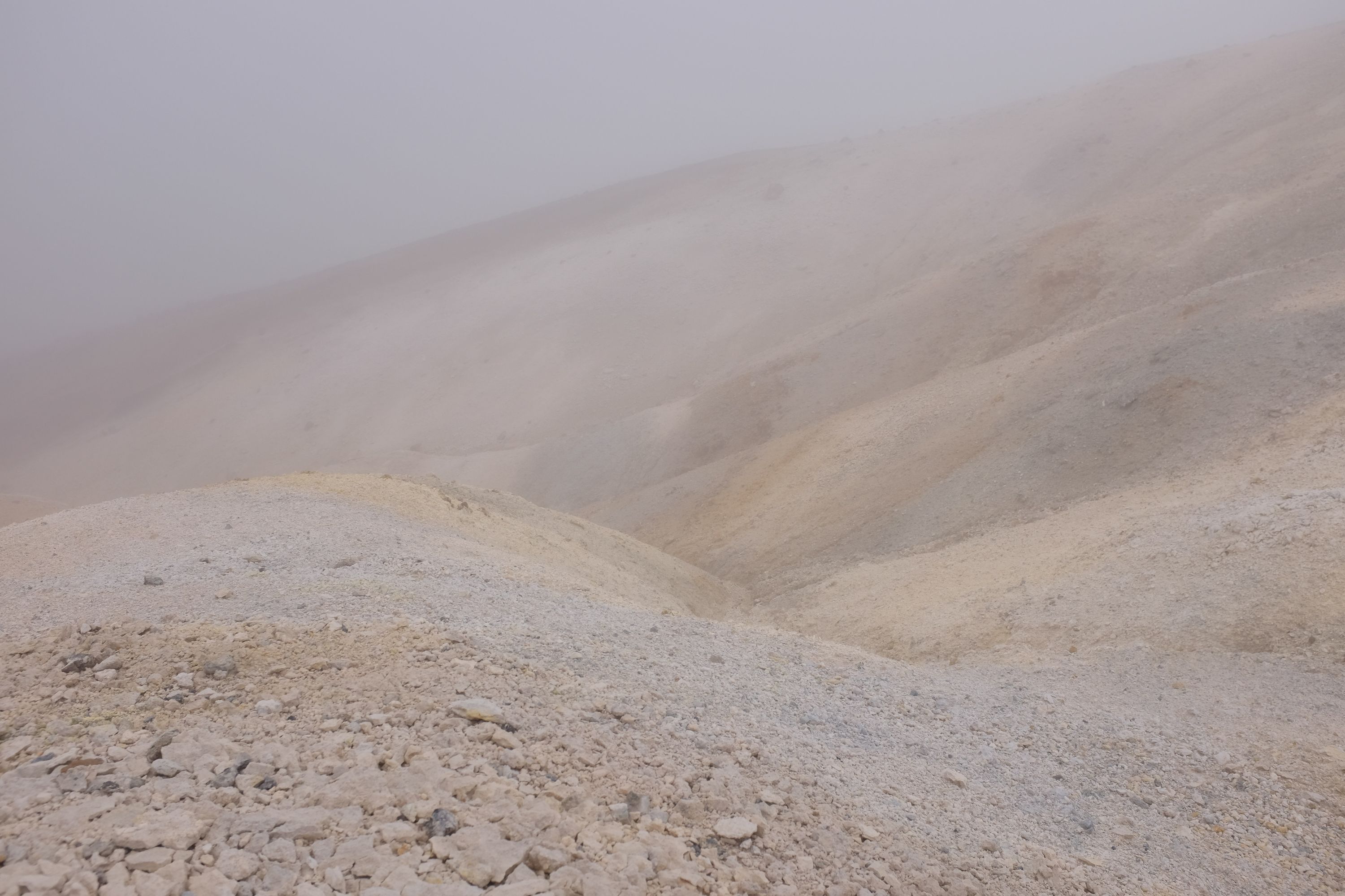A landscape of bare white pebbles in the fog.