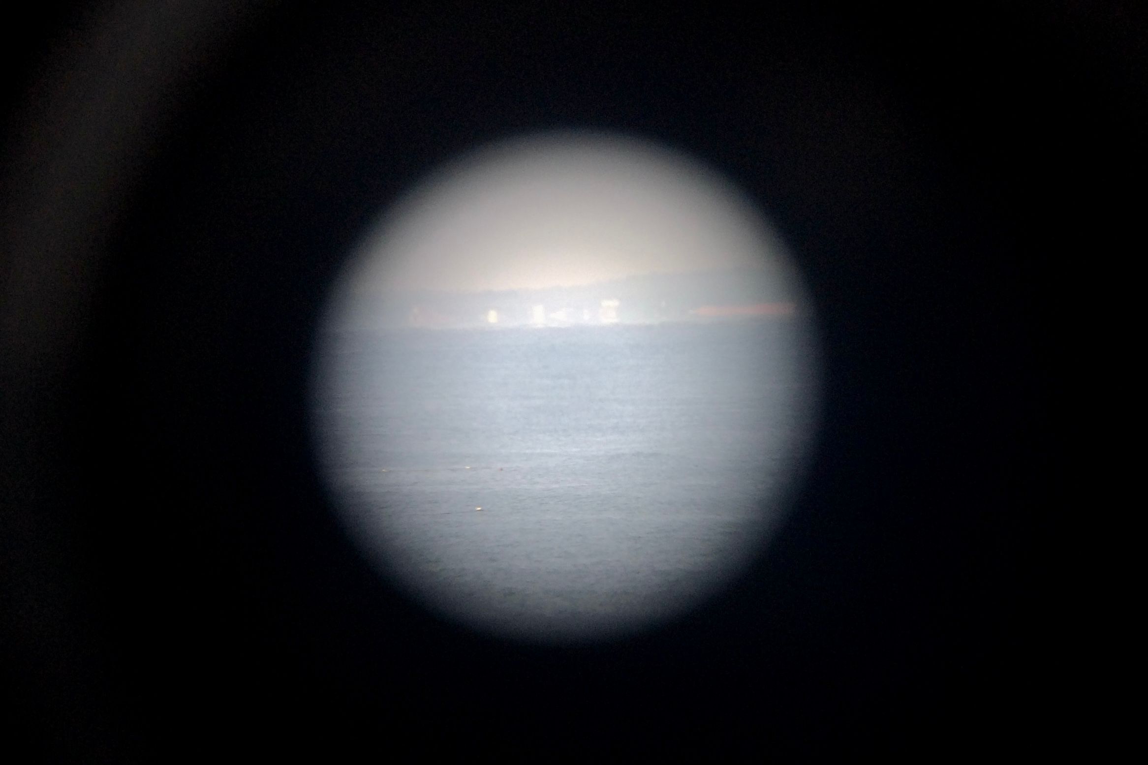 The outline of a town seen through a high-powered scope.