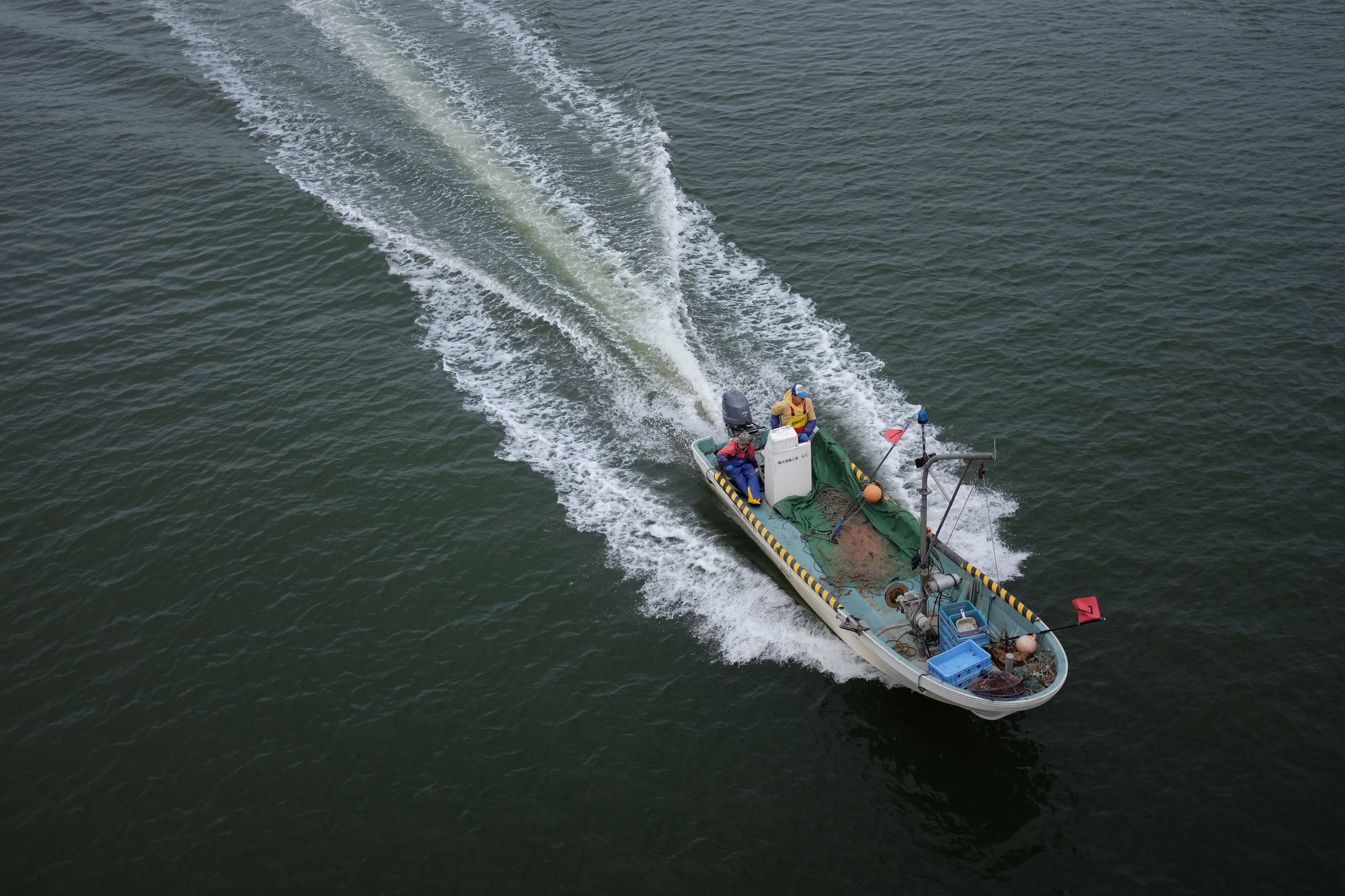 An overhead view of a fishing boat going at speed.