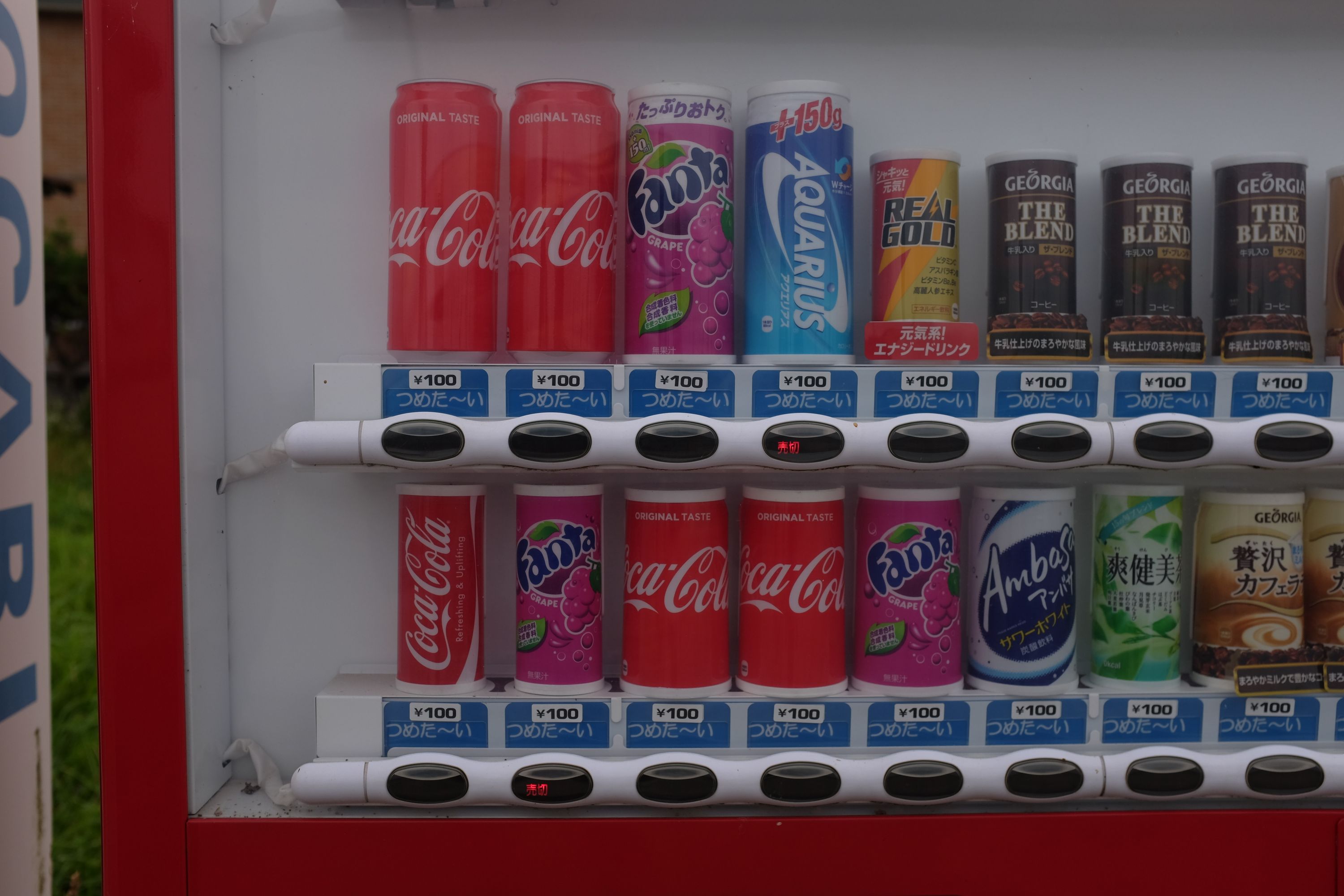 A vending machine sells, among other things, various sizes of Coke all costing ¥100.