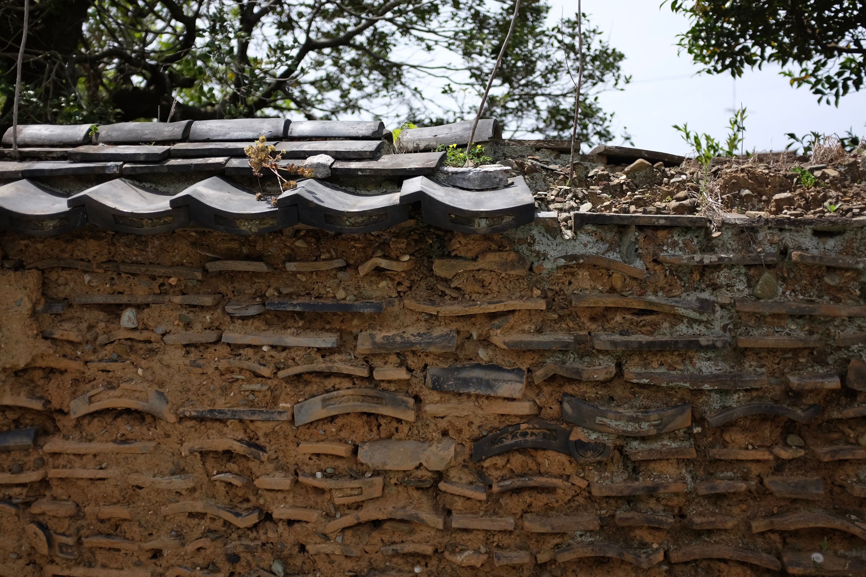 Wall made of old roof tiles reinforced with mud.