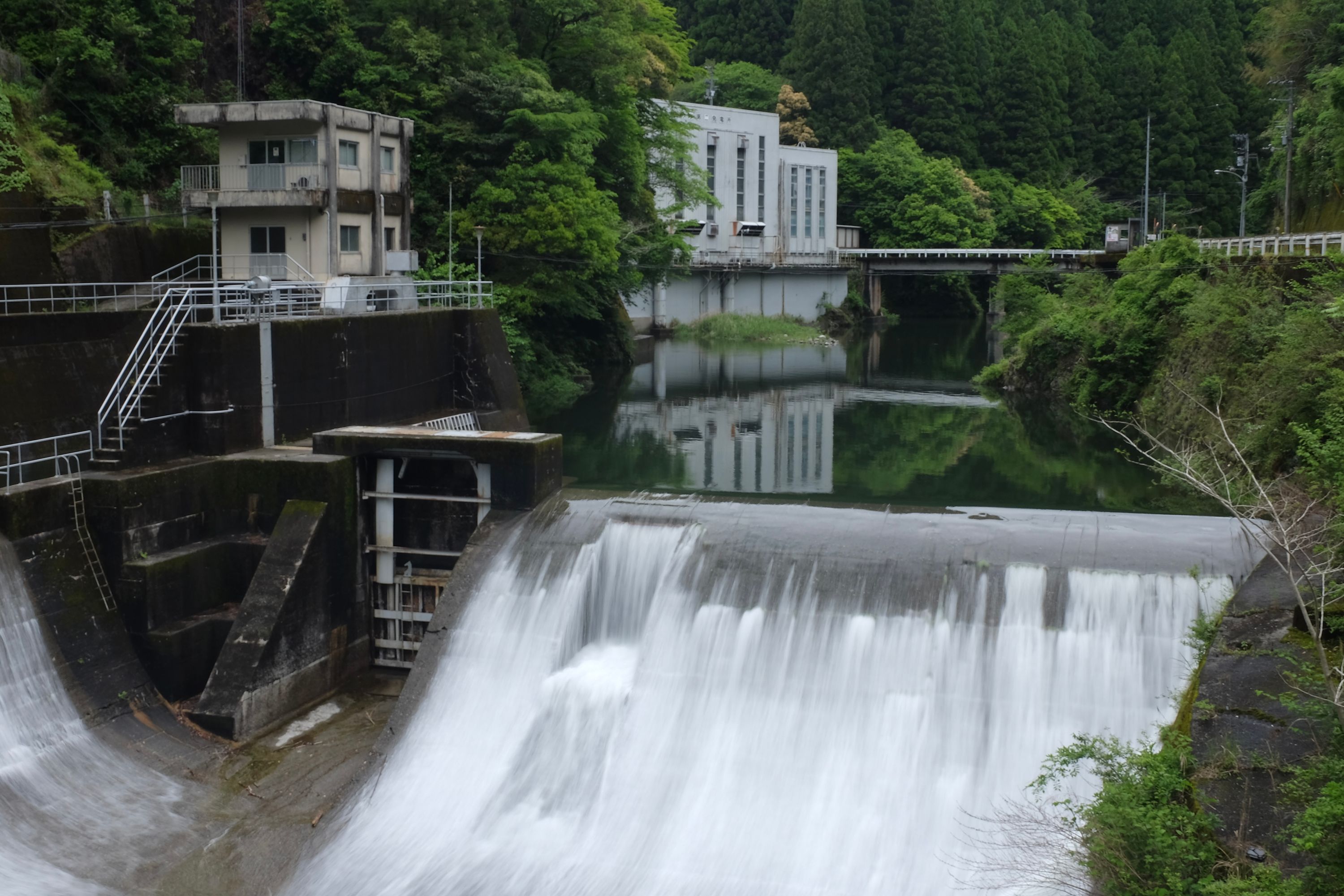 Water cascades over the dam of a small hydroelectric power station.