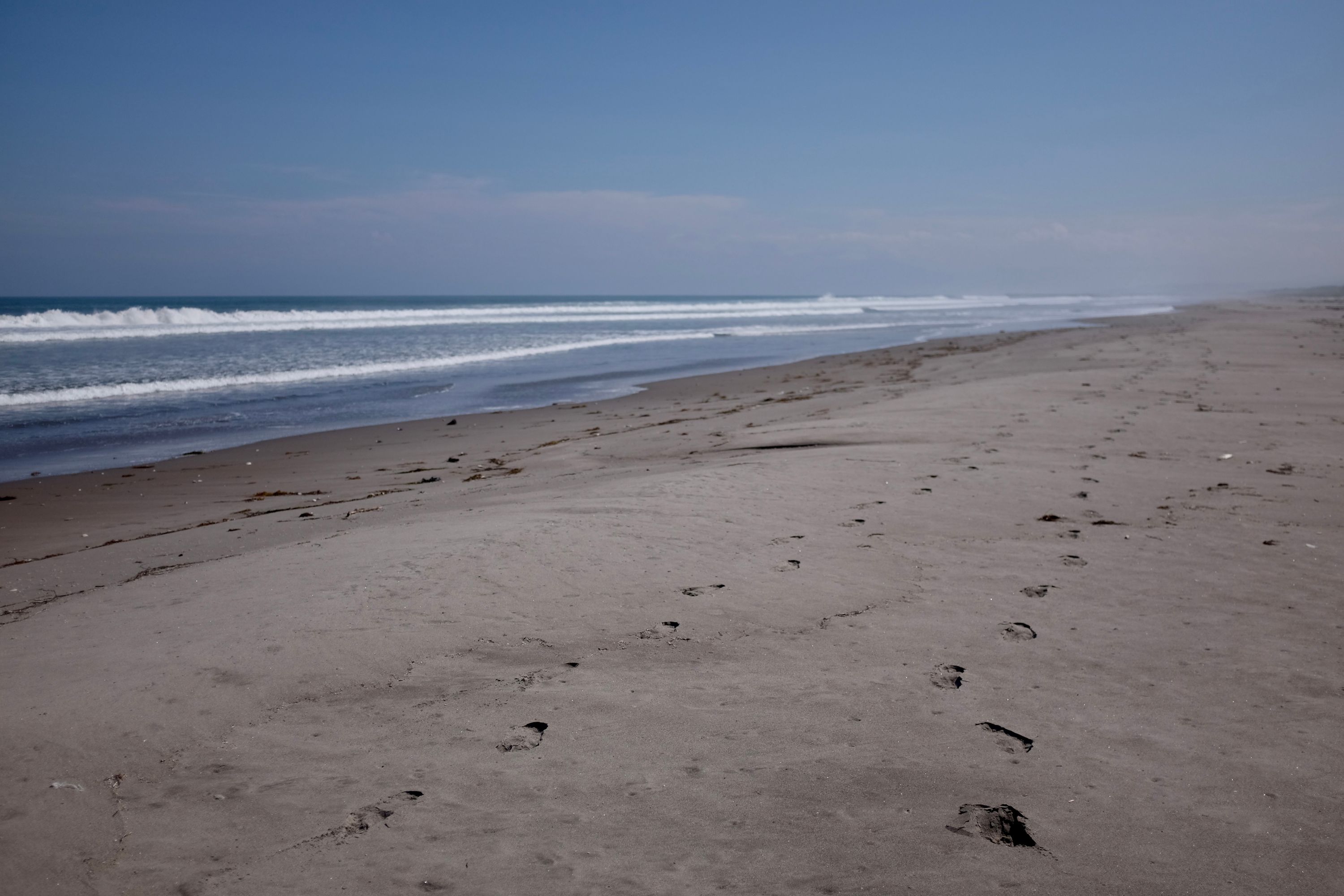 Looking back on the beach, two pairs of footprints recede into the distance.