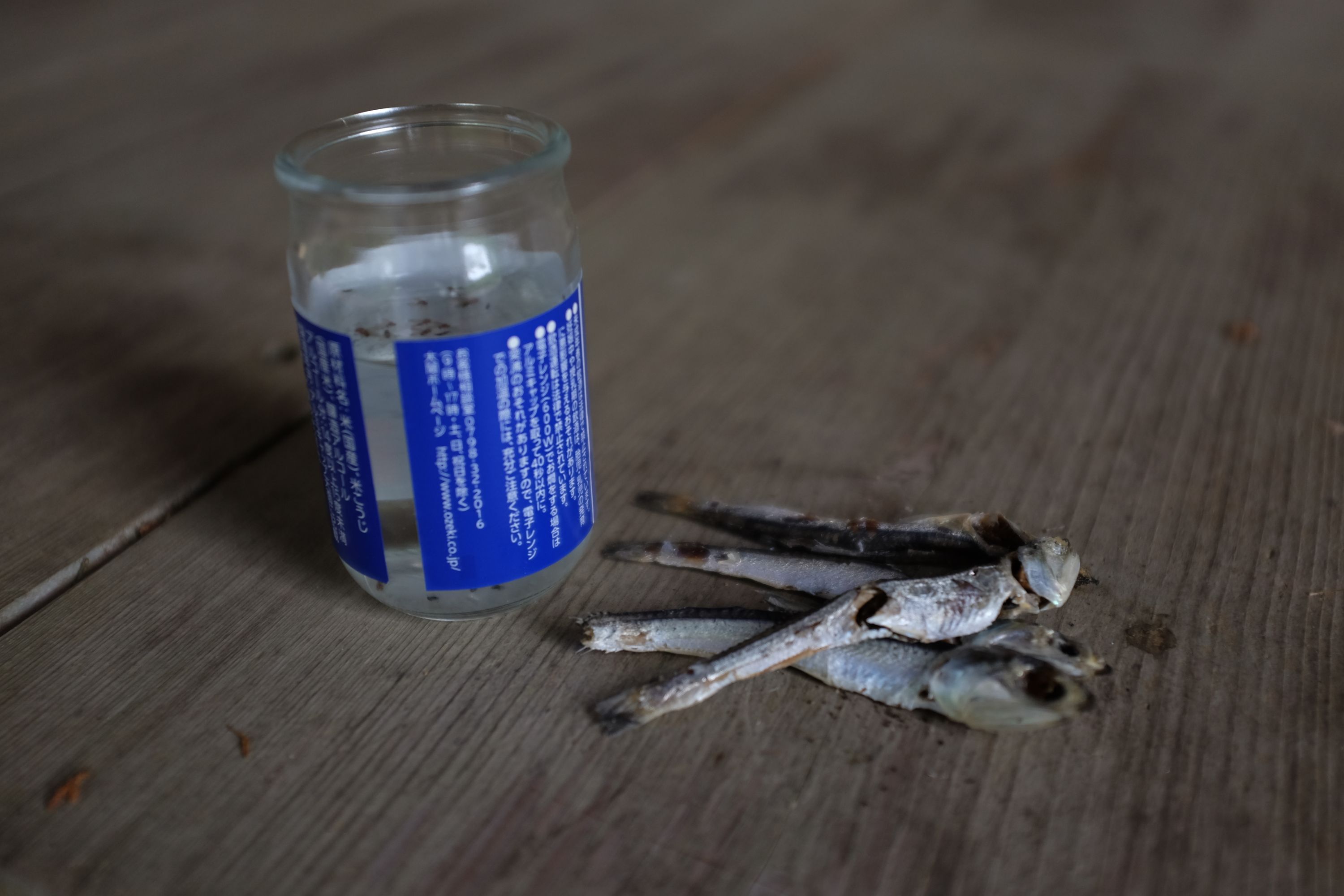 A cup of sake and four dried anchovies placed on the porch of a shrine as an offering to the gods.