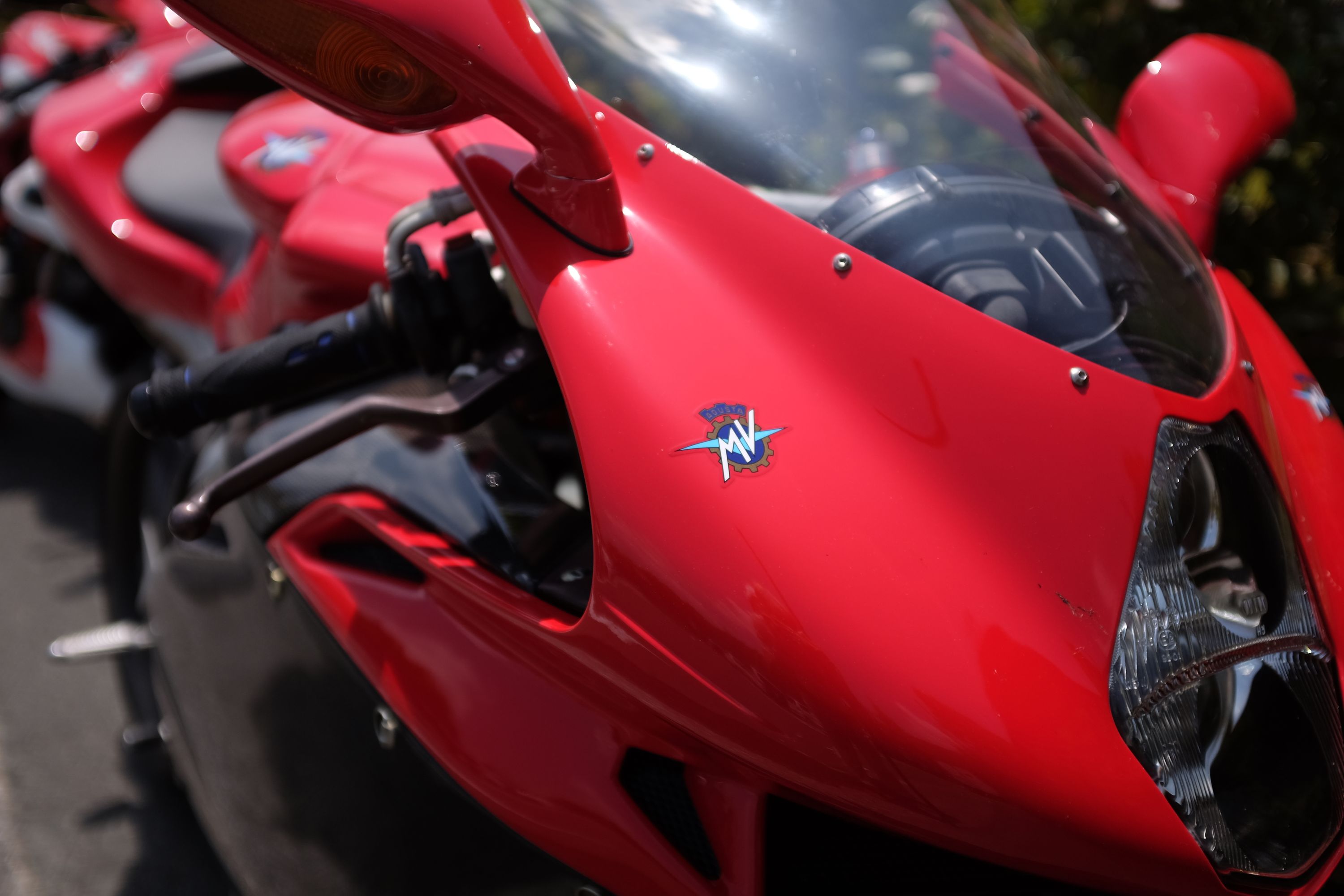 Looking up close at the windscreen and headlight of a red MV Agusta F4, a very fast Italian sports bike.
