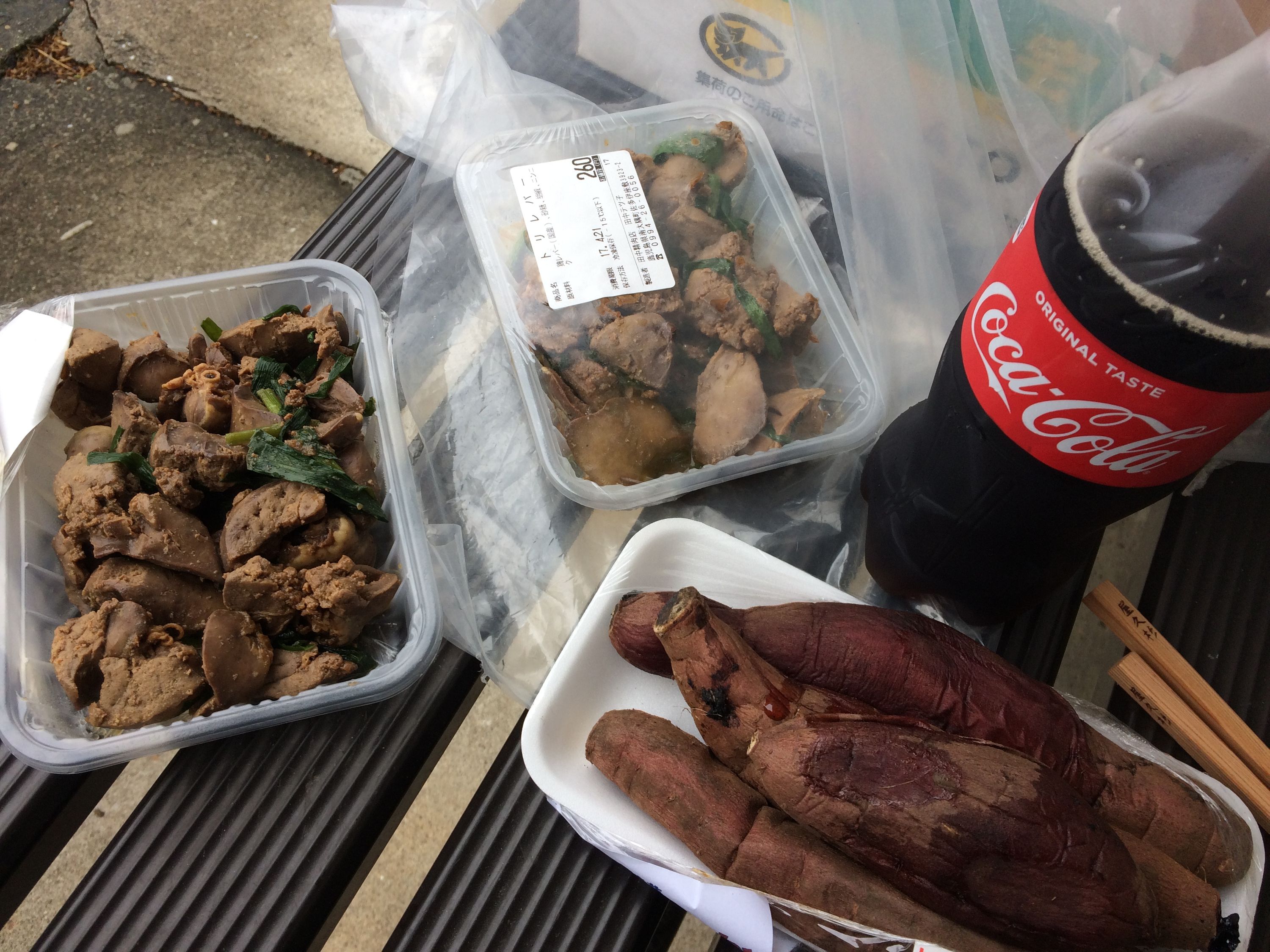 Sautéed livers, baked sweet potatoes, and a bottle of Coke on a bench.