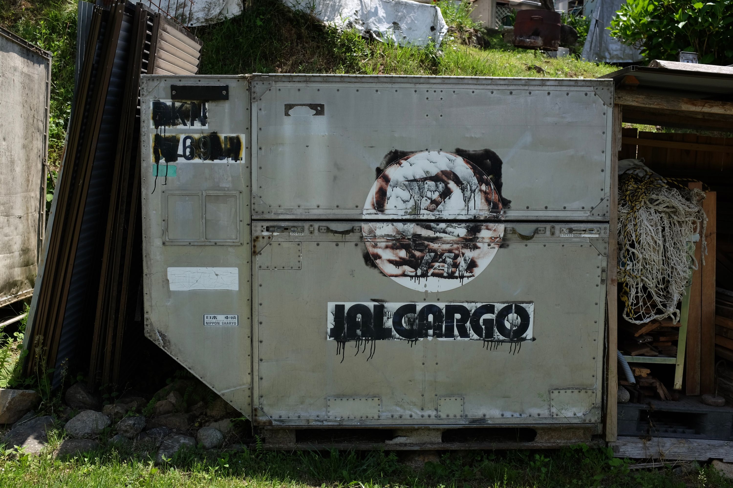 A Japan Airlines cargo container used as a shed in someone’s backyard.