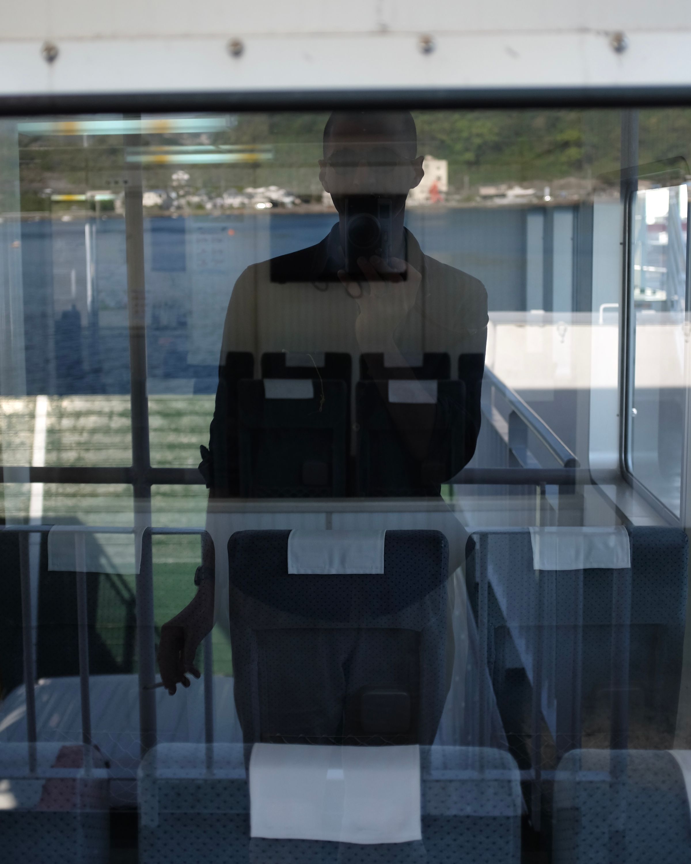 The author reflected in the window of a ferry.