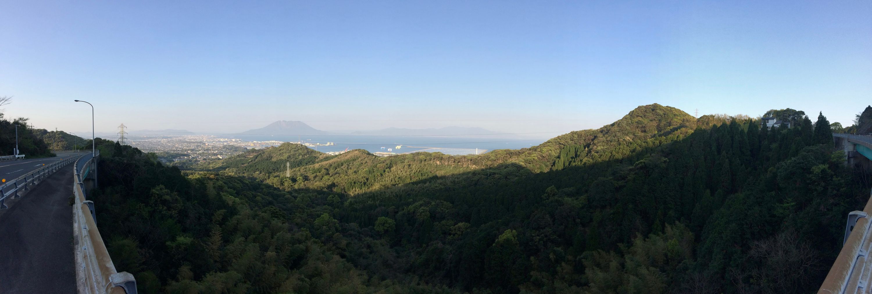 A panorama of green hills, Kagoshima City, and Sakurajima.