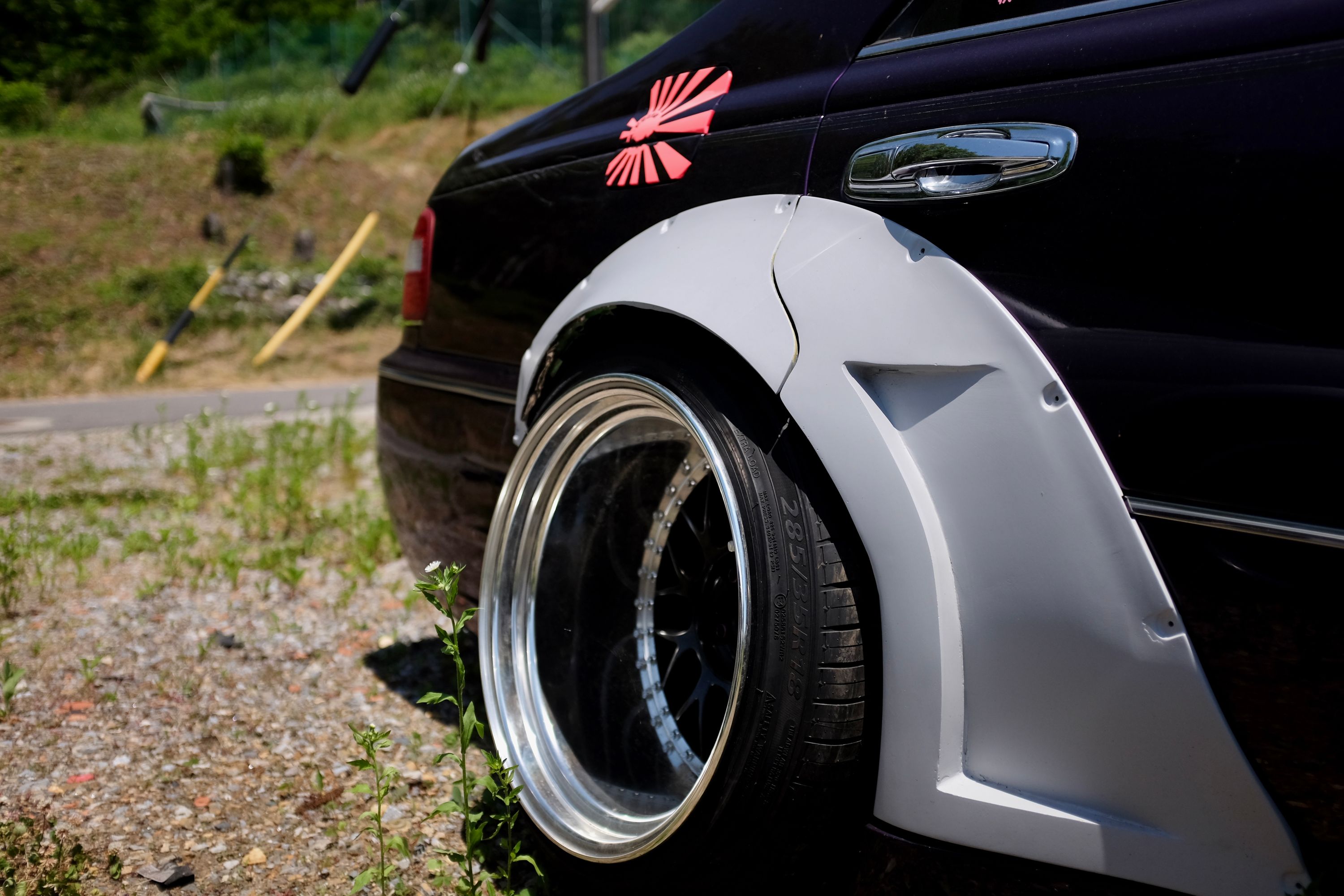 Closeup of a rear wheel of the bosozuku-style purple Nissan.