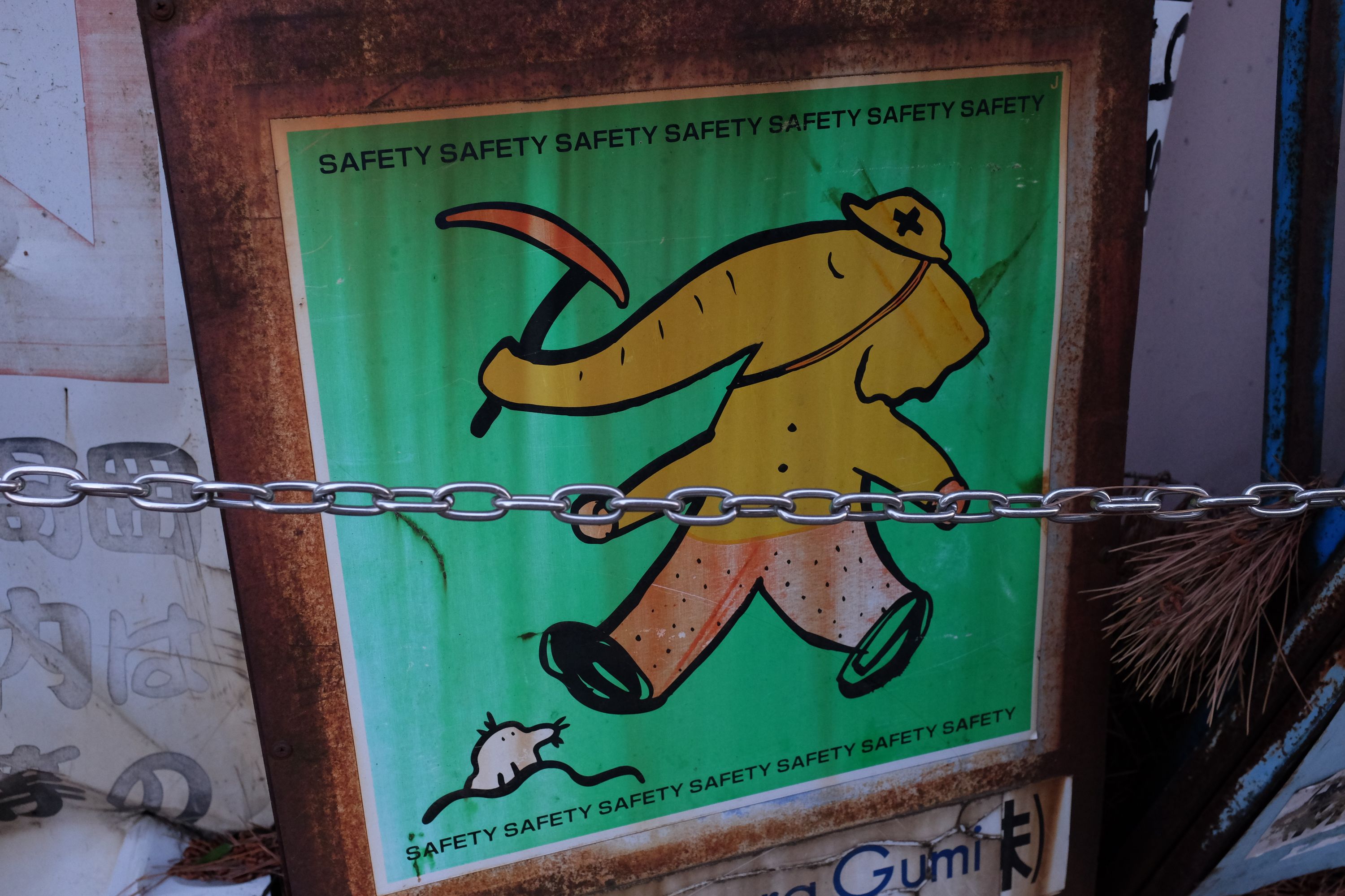 Sign of an elephant dressed as a construction worker, carrying a pickaxe in its trunk.