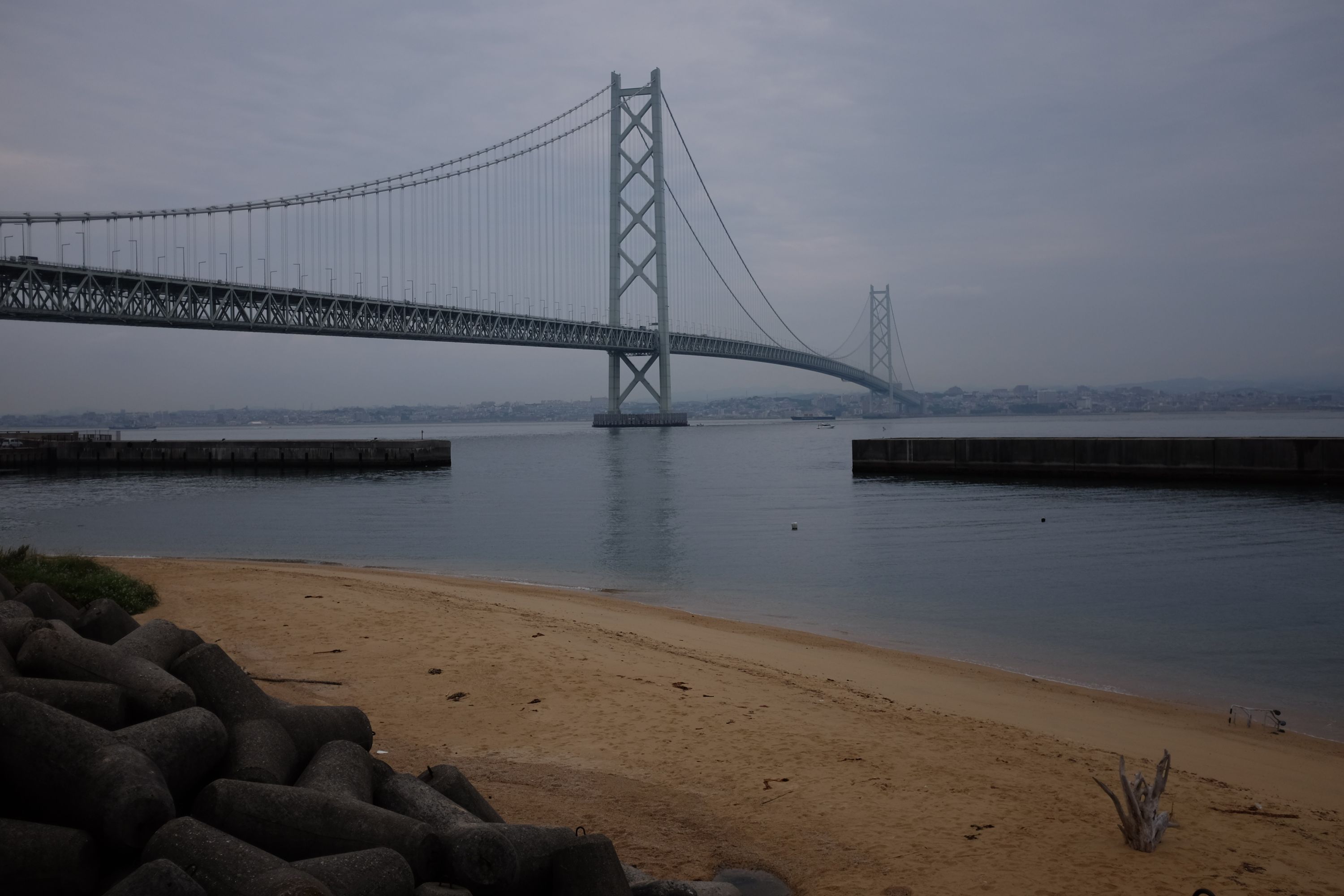 The Akashi Kaikyō Bridge as seen from a sandy beach.