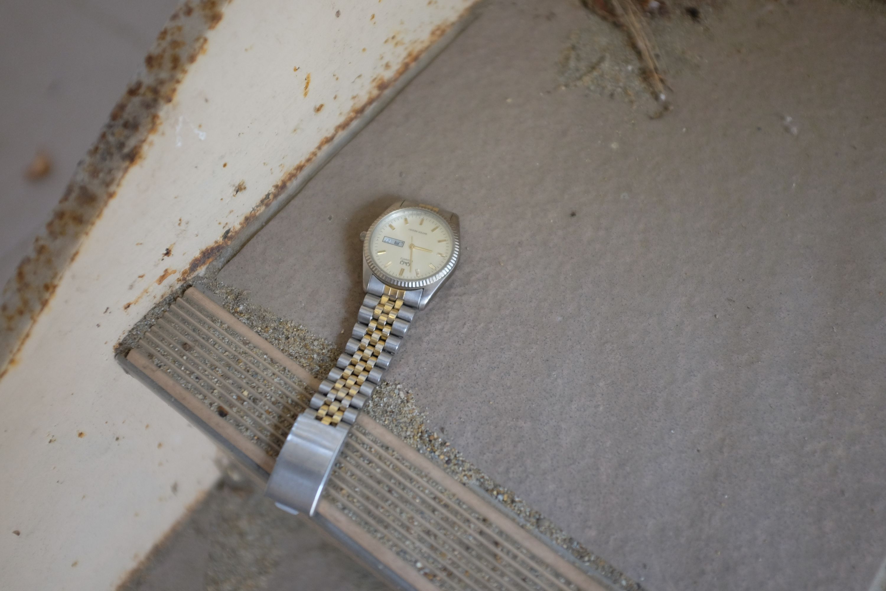An abandoned metal wristwatch on the stairs.