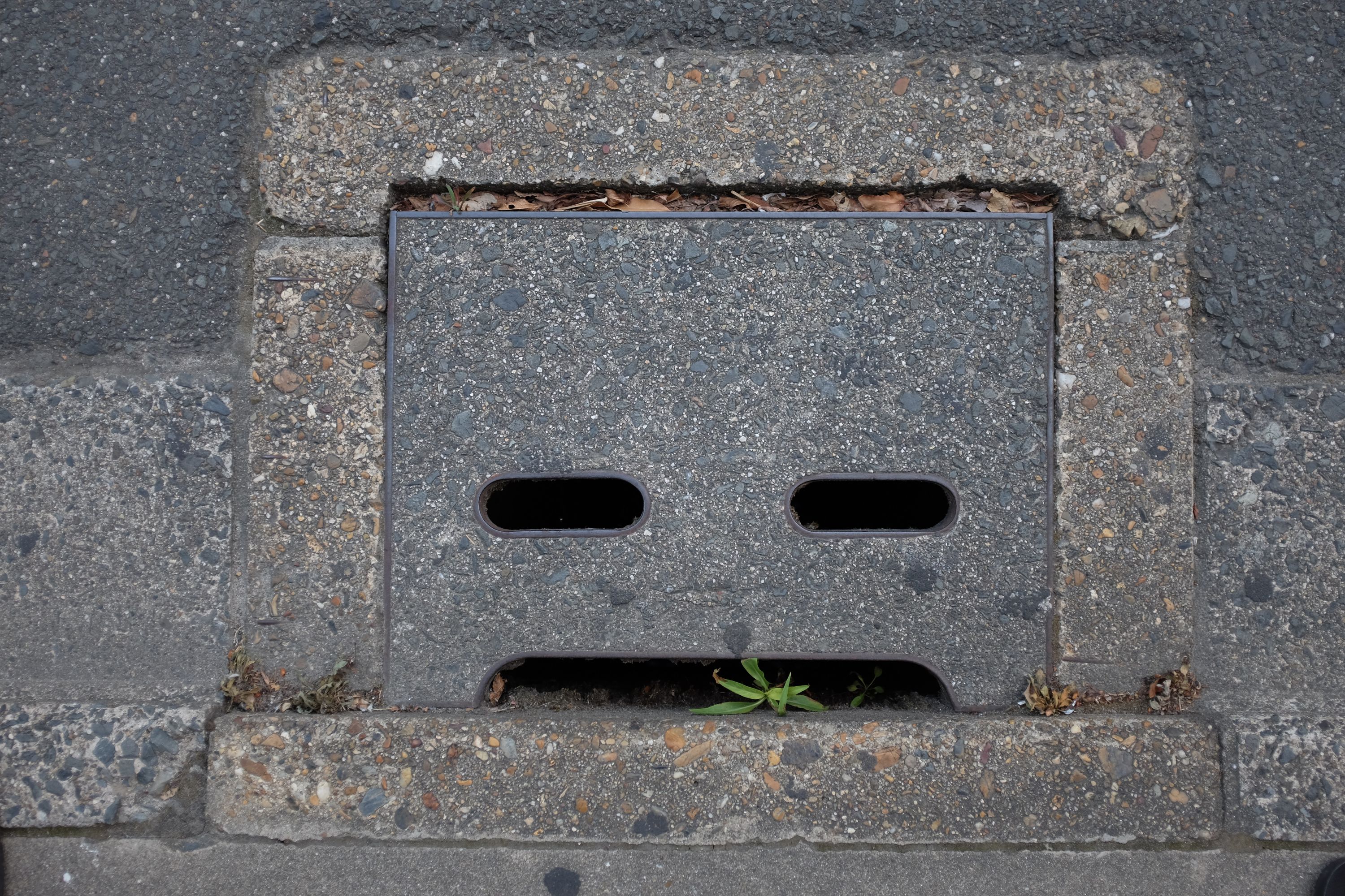 A concrete storm drain shaped like an angry robot face.