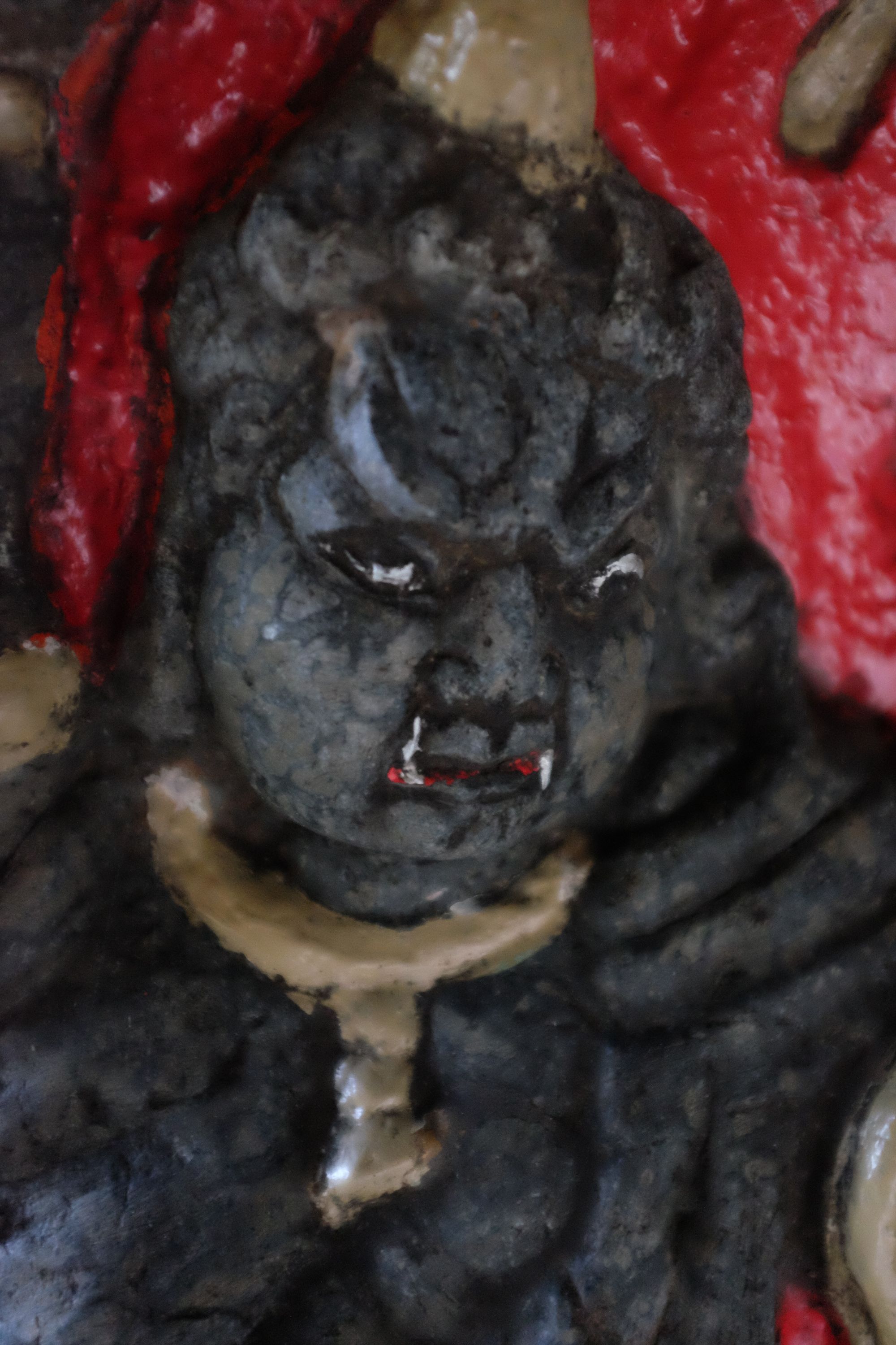 A fierce-looking statue of a guardian at a Shinto shrine.