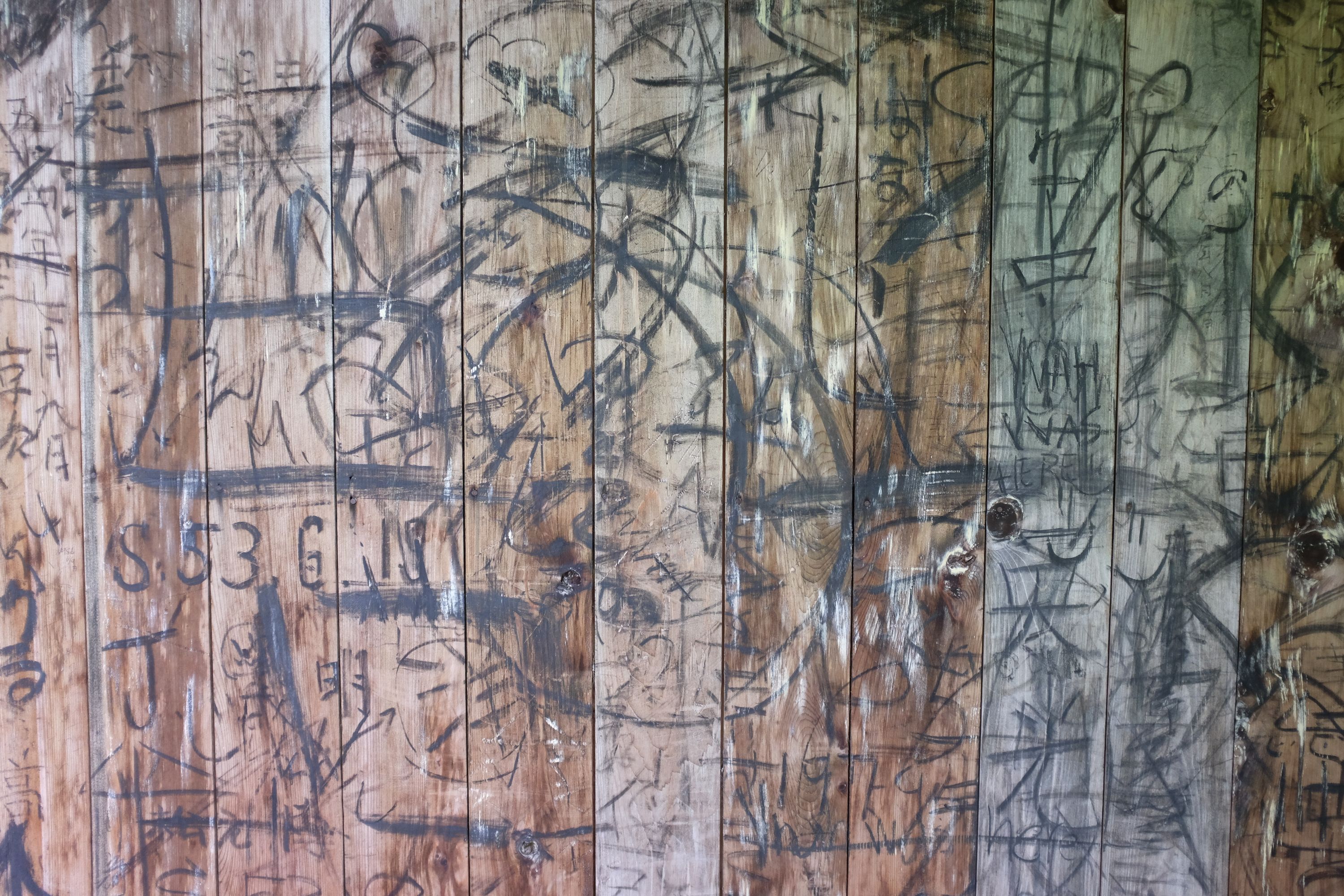 Wooden planks covered in Japanese scribbles.