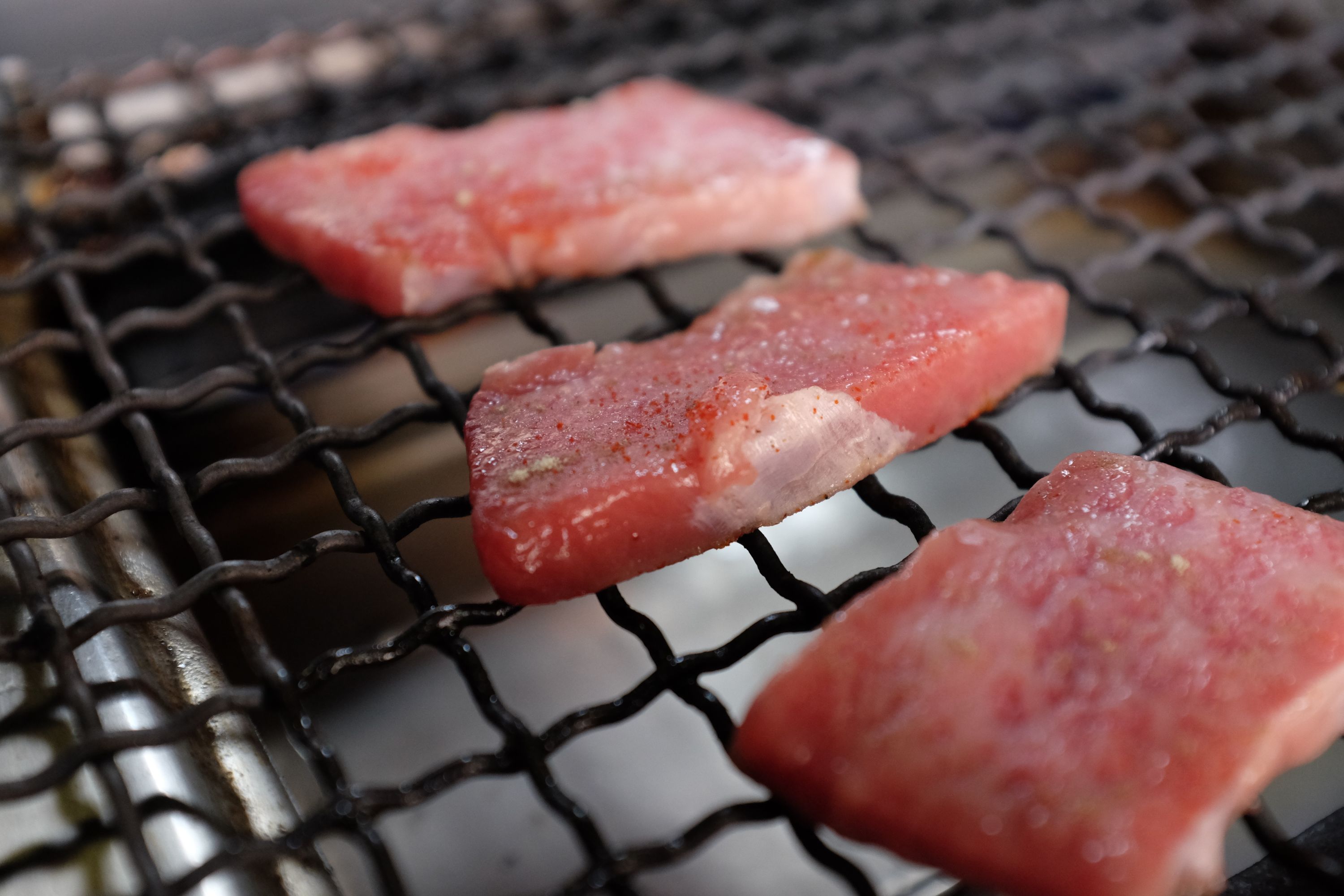 Pieces of Kōbe beef on a grill.