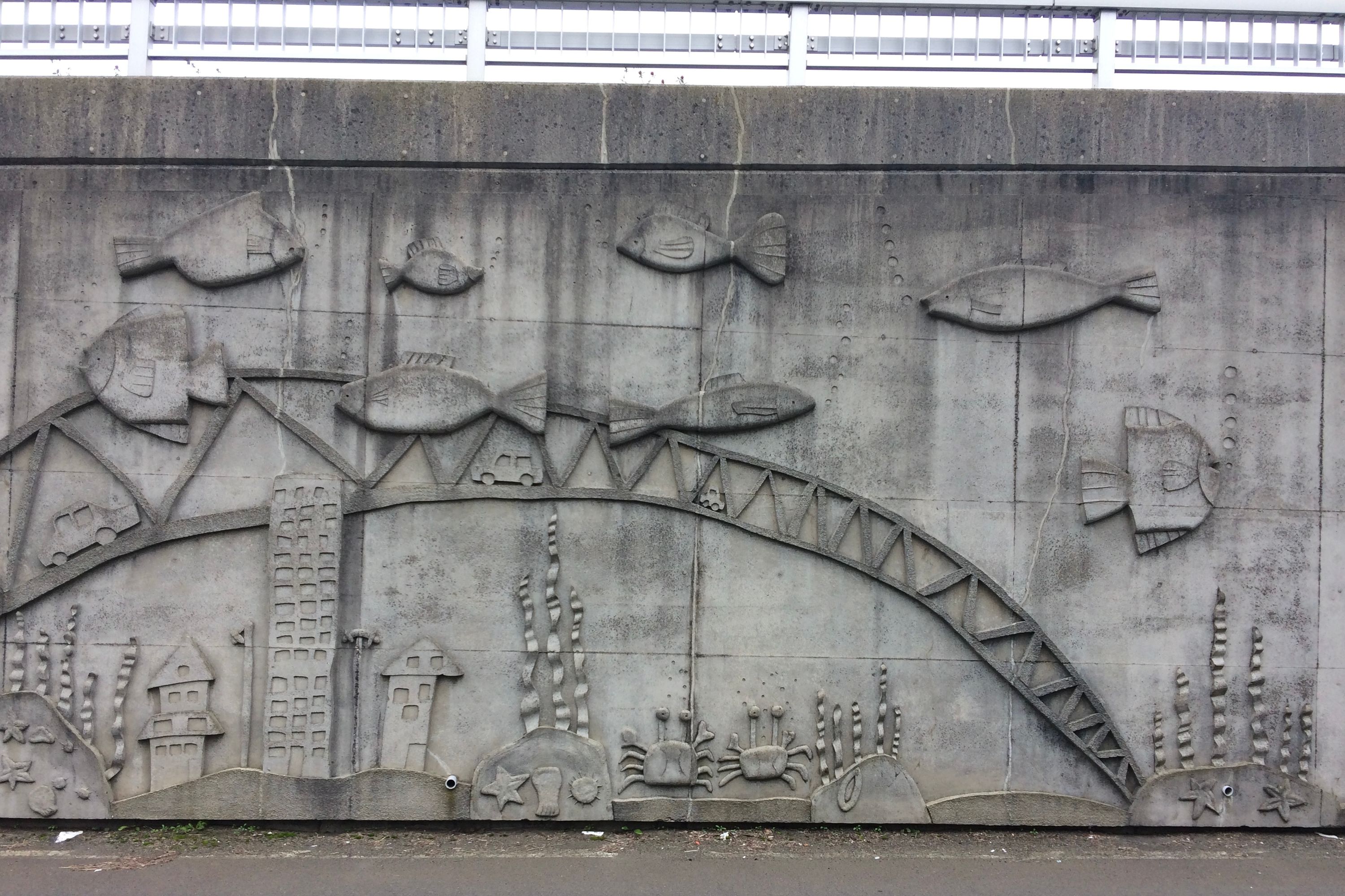 A concrete relief of an underwater scene on an overpass.