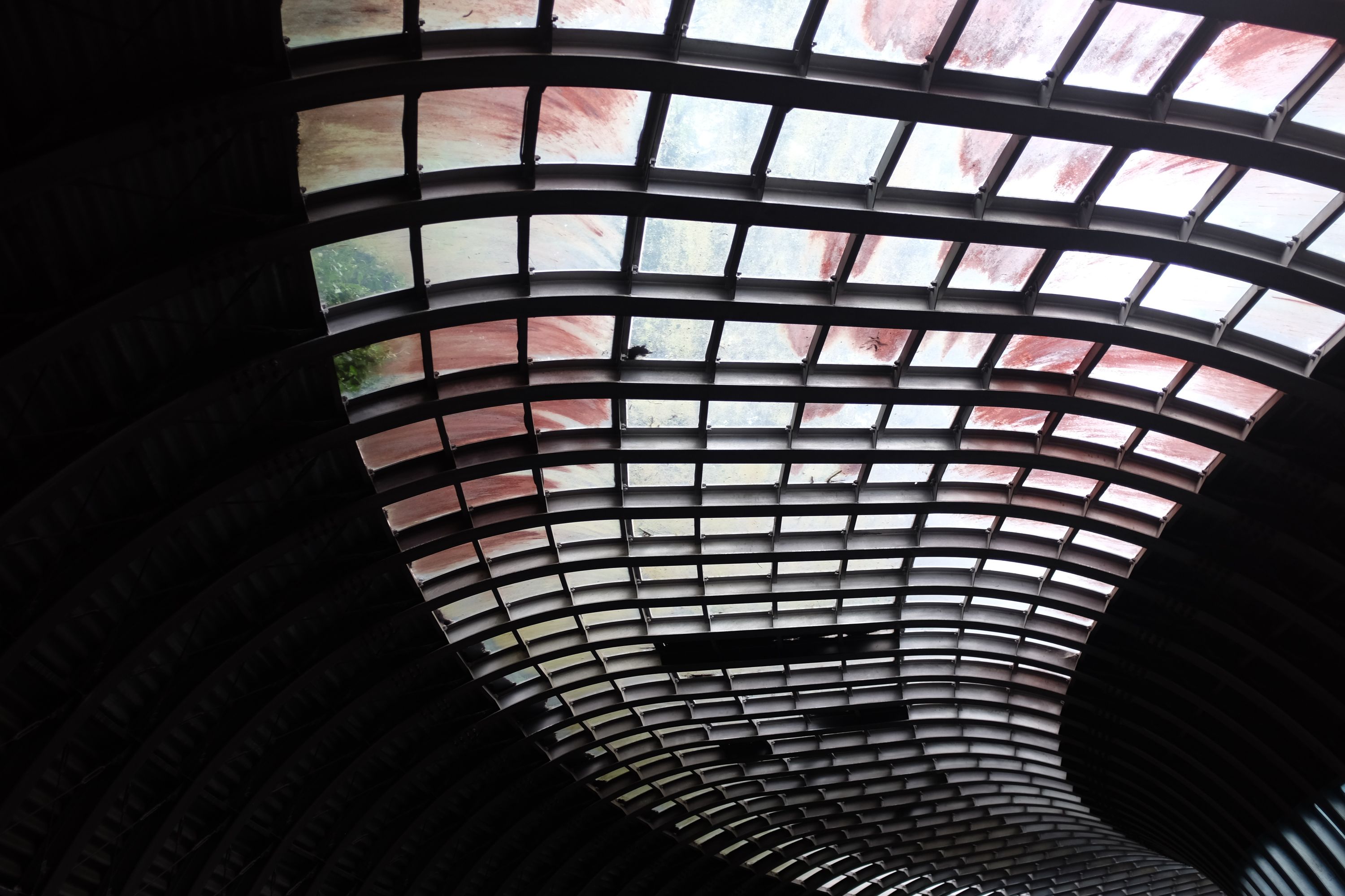 Looking up through the tiled, translucent roof of a tunnel.