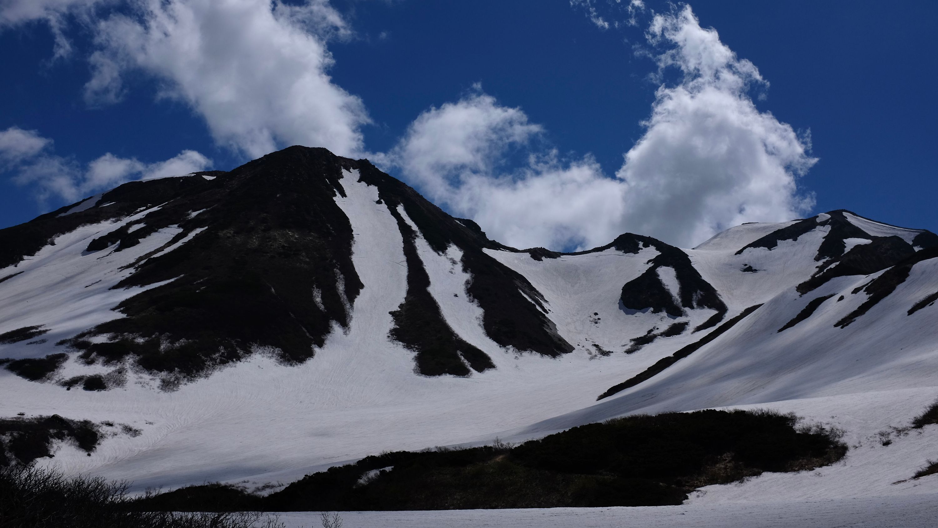 Looking back on the summit peaks of Hakusan, mostly covered in snow.